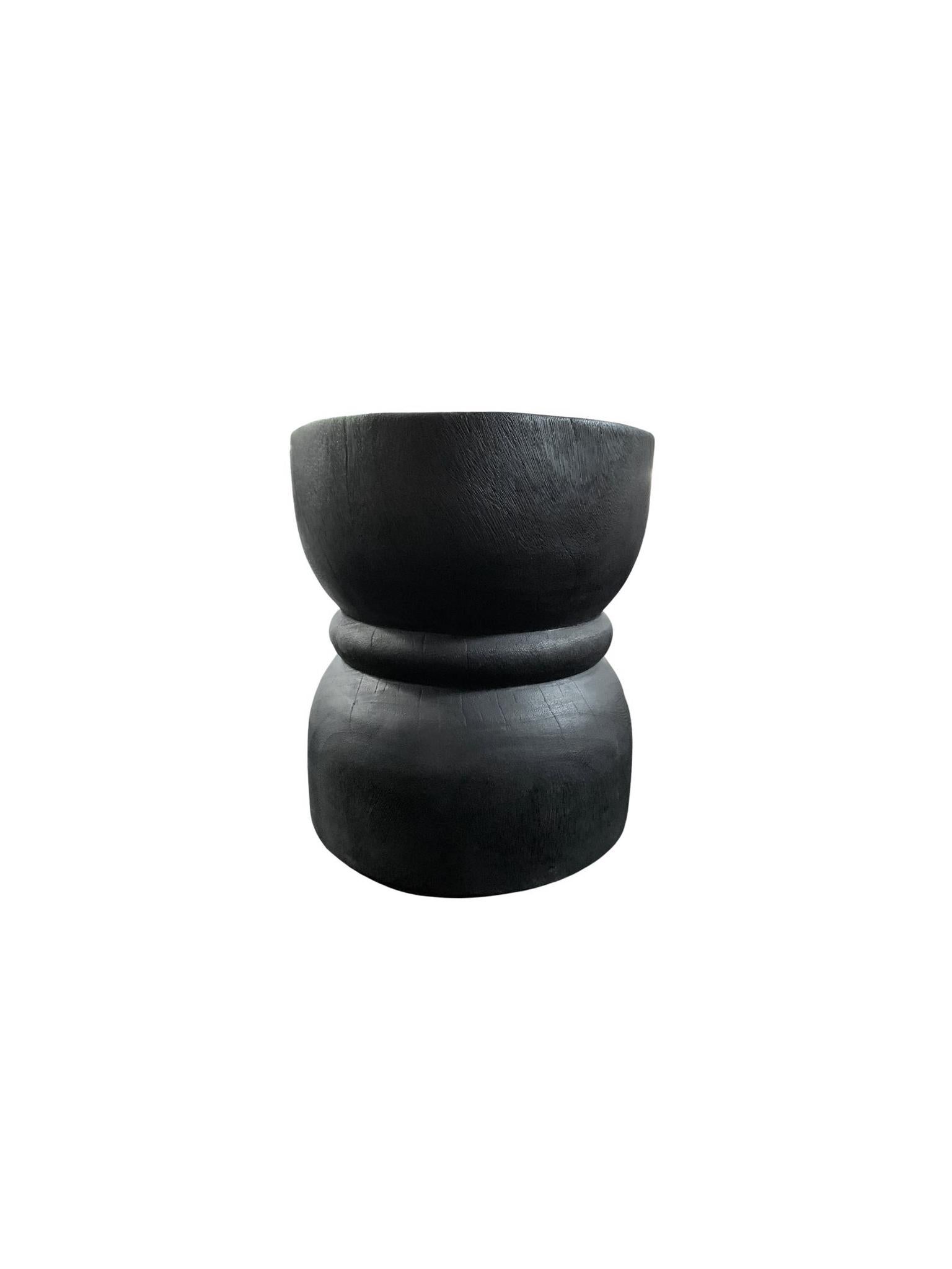 A wonderfully sculptural round side table. Its black pigment was achieved through a burning process creating both a wonderful colour and effect. Its neutral pigment and subtle wood texture makes it perfect for any space. A uniquely sculptural and