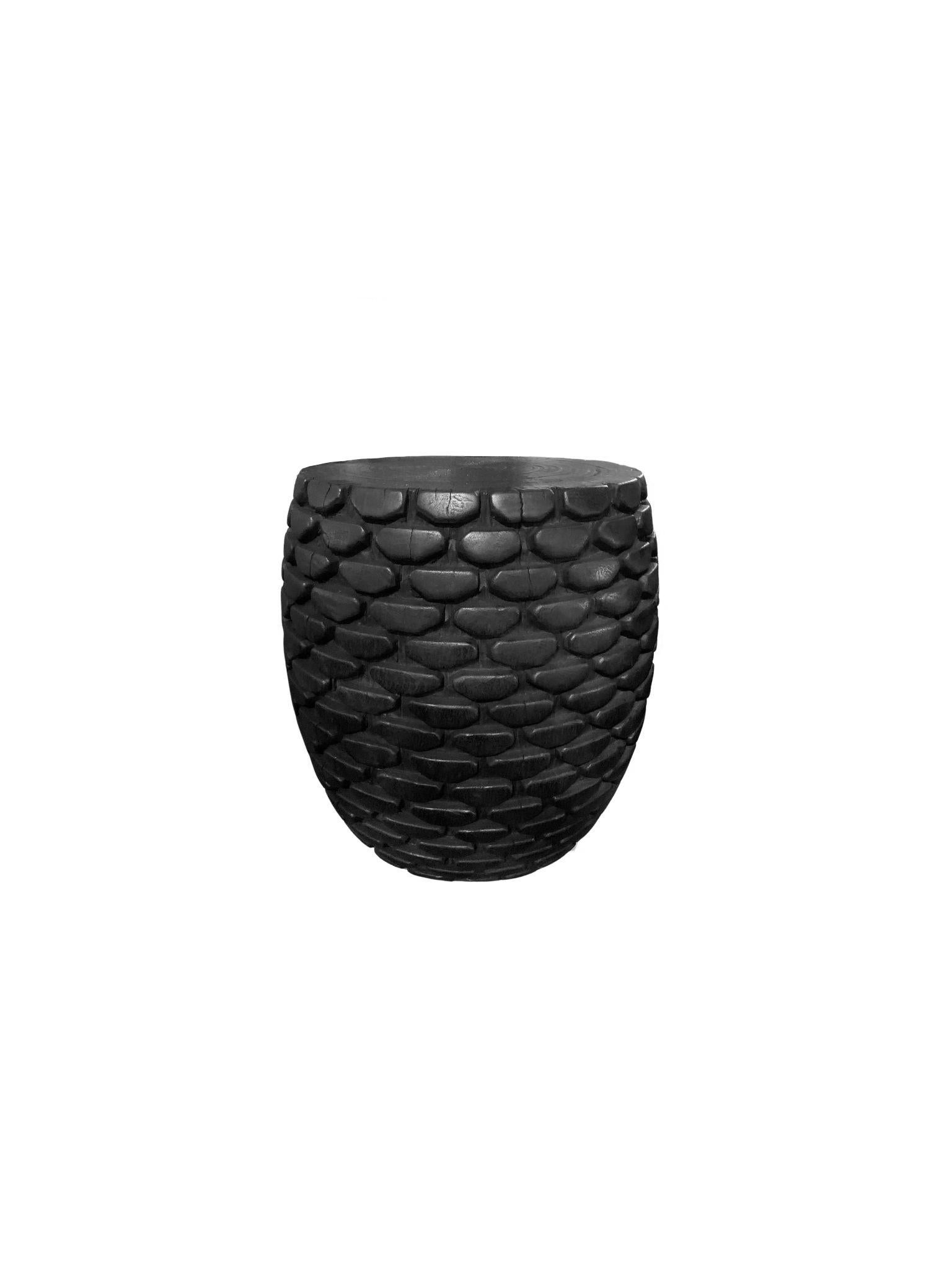Une table d'appoint ronde merveilleusement sculpturale. Son pigment noir est obtenu par un processus de brûlage qui crée une couleur et un effet merveilleux. Son pigment neutre et sa texture boisée subtile s'intègrent parfaitement à tous les