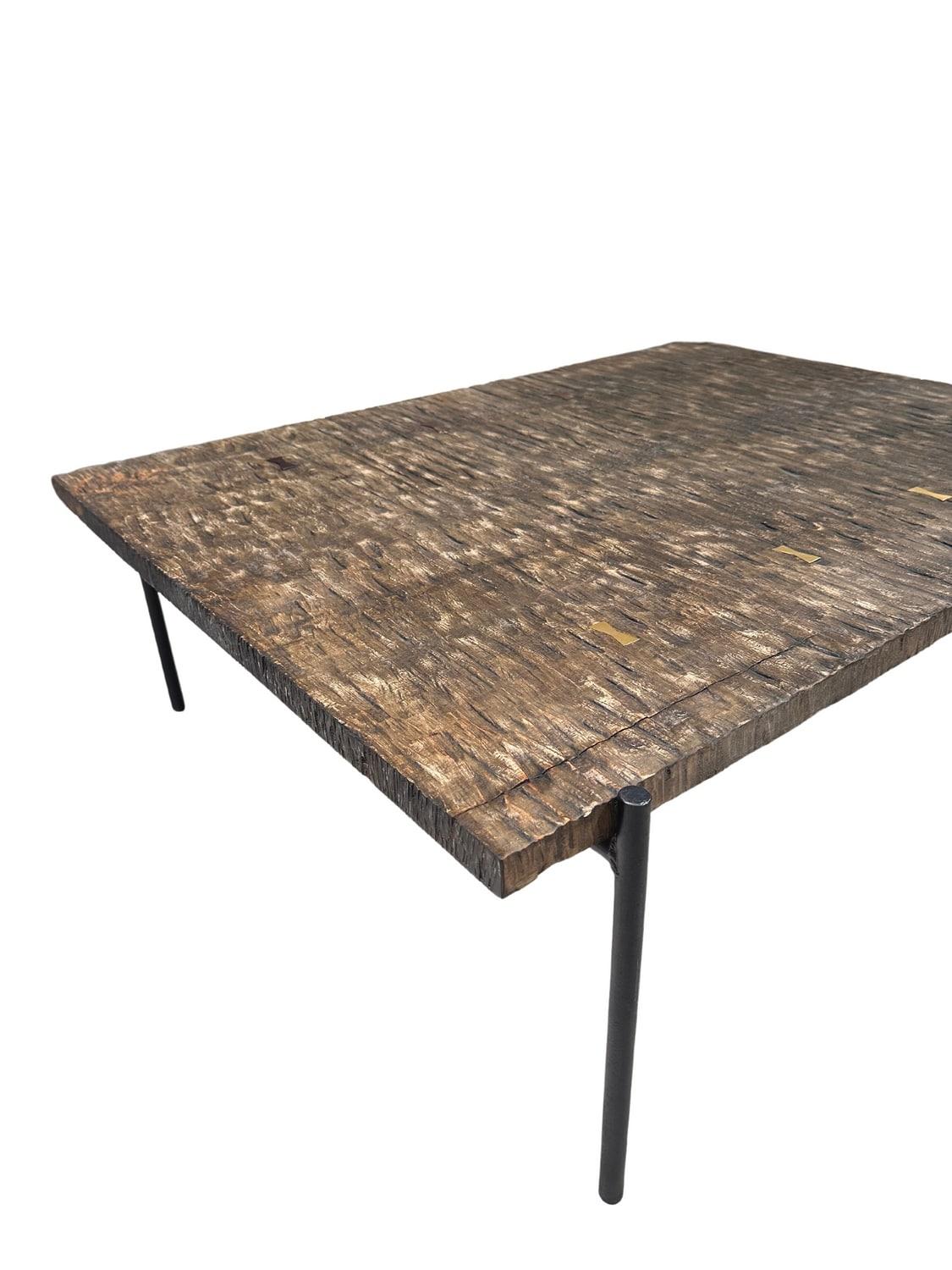 Crafted from solid maple wood, this table boasts a rich, natural texture that adds sophistication to any living space. The table has a simple design with a rectangular shape and with a rough, natural texture on its surface. The wood appears to have