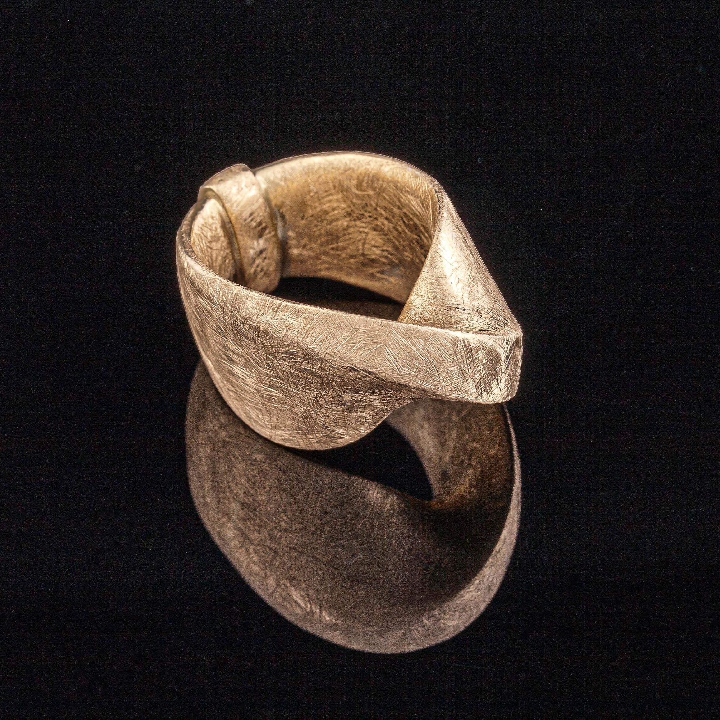Cette bague torsadée est réalisée en or jaune 18 carats avec une finition grattée unique qui crée une texture particulière. L'utilisation d'une technologie de pointe pour créer ce bijou artistique unique. Il s'agit d'une bague moderne en or Mobius
