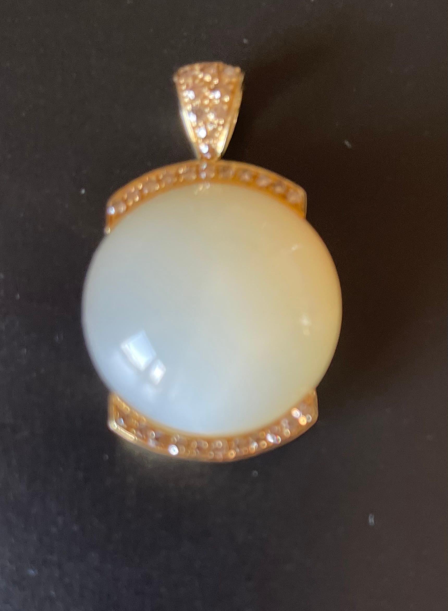 Very solid and bold modern Moonstone Pendant in 18 K yellow Gold. The pendant is featuring a large yellowish cream colored Moonstone Cabochon weighing 37.10 ct and 37 Champagne colored Diamonds totalling 1.10 ct. 
Masterfully handcrafted piece!