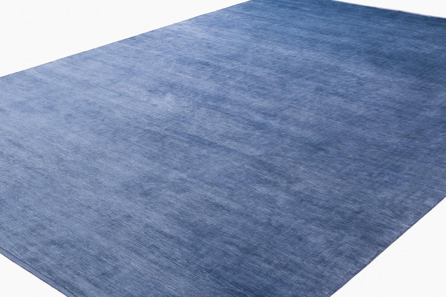 This undeniably luxurious silk area rug by Joseph Carini is truly incredible. Hand-knotted with the finest Chinese silk, the high knot count (200 knots), exudes a wonderful sheen and is ultra soft to the touch. This blue carpet transforms from light