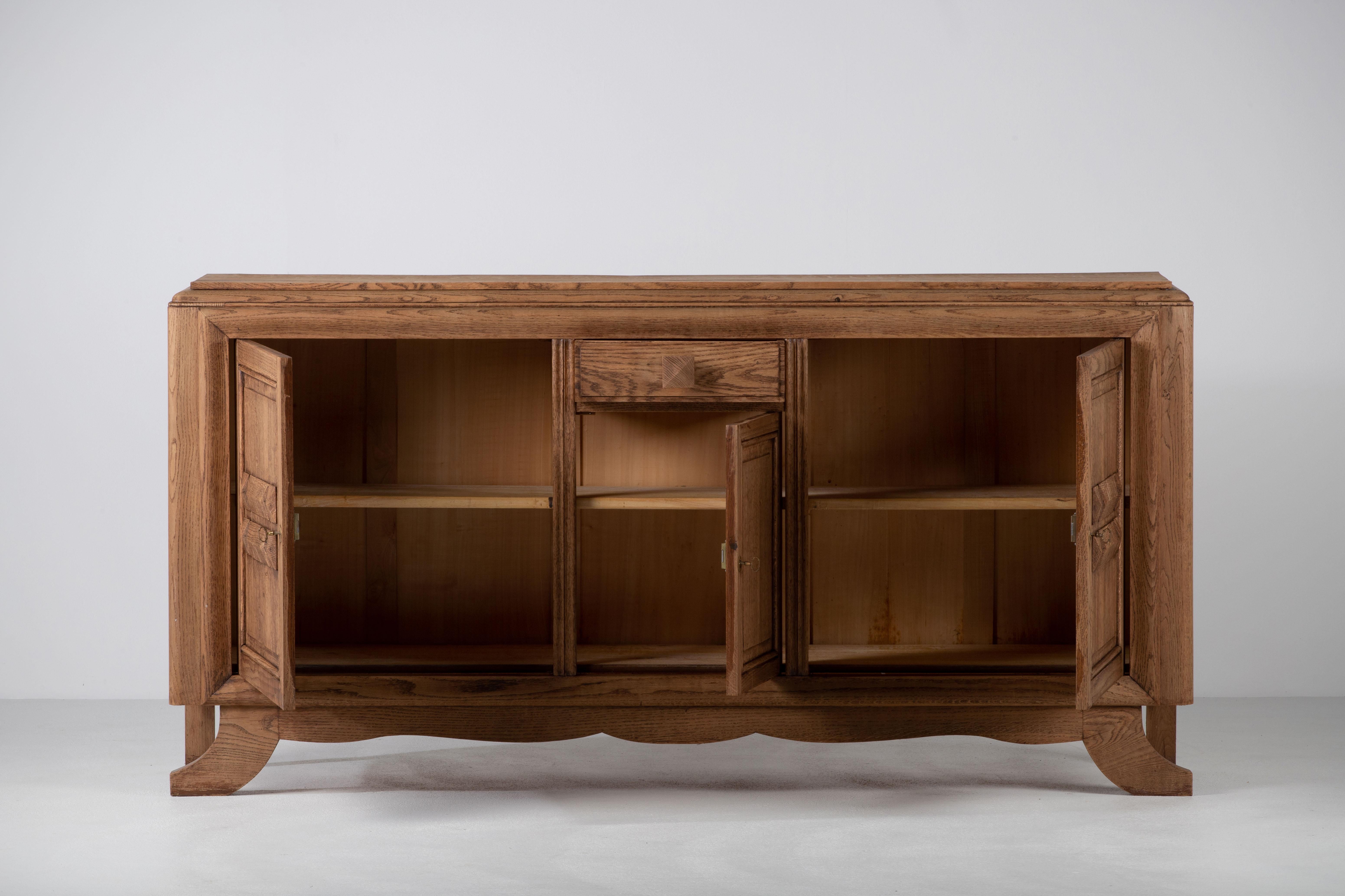 Credenza, solid natural oak, France, 1940s.
The credenza consists of three storage facilities, covered with very detailed designed doors.
Good Vintage condition.
 