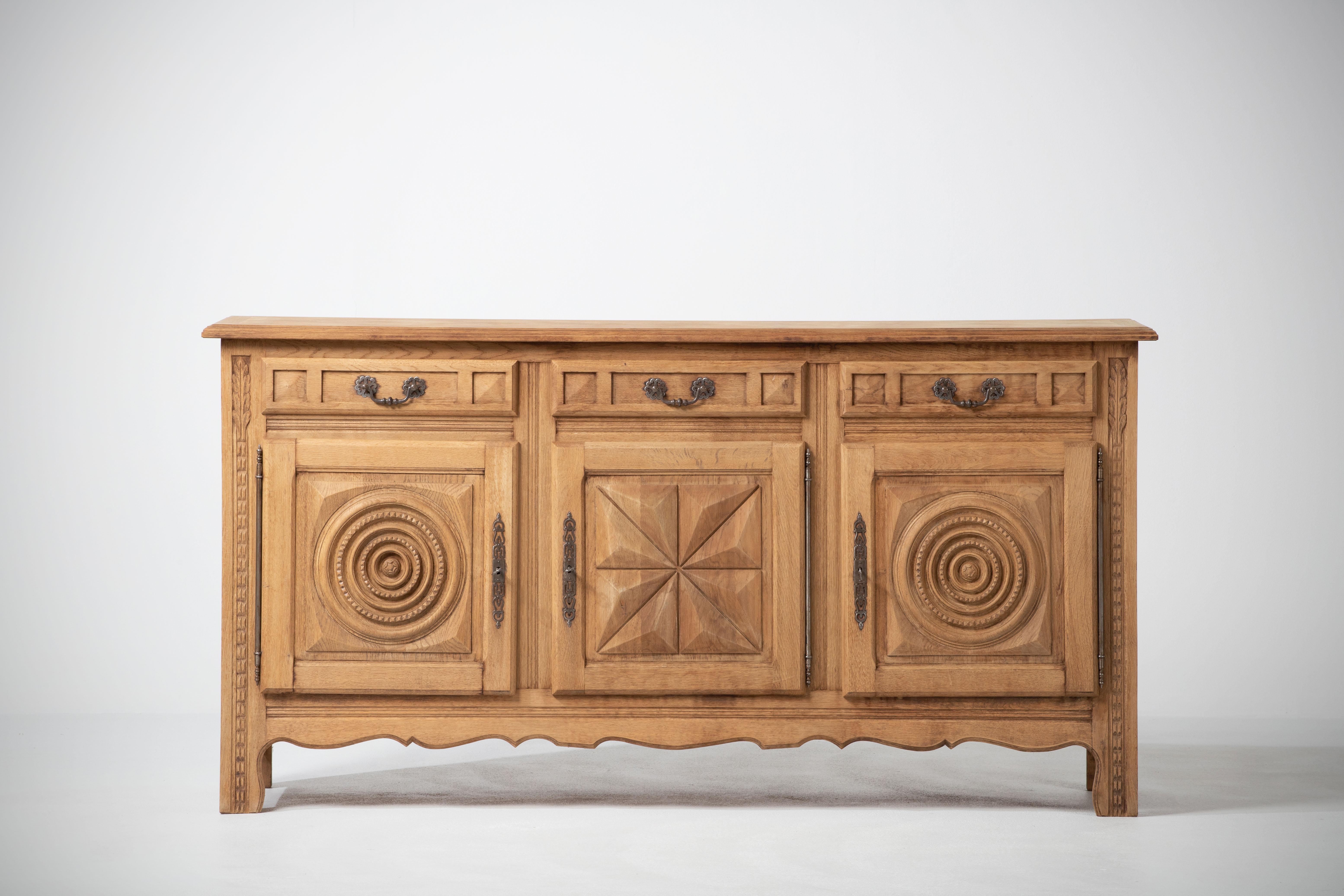 Credenza, solid natural oak, France, 1940s.
The credenza consists of three storage facilities and drawers, covered with very detailed designed doors.
Good Vintage condition.
 