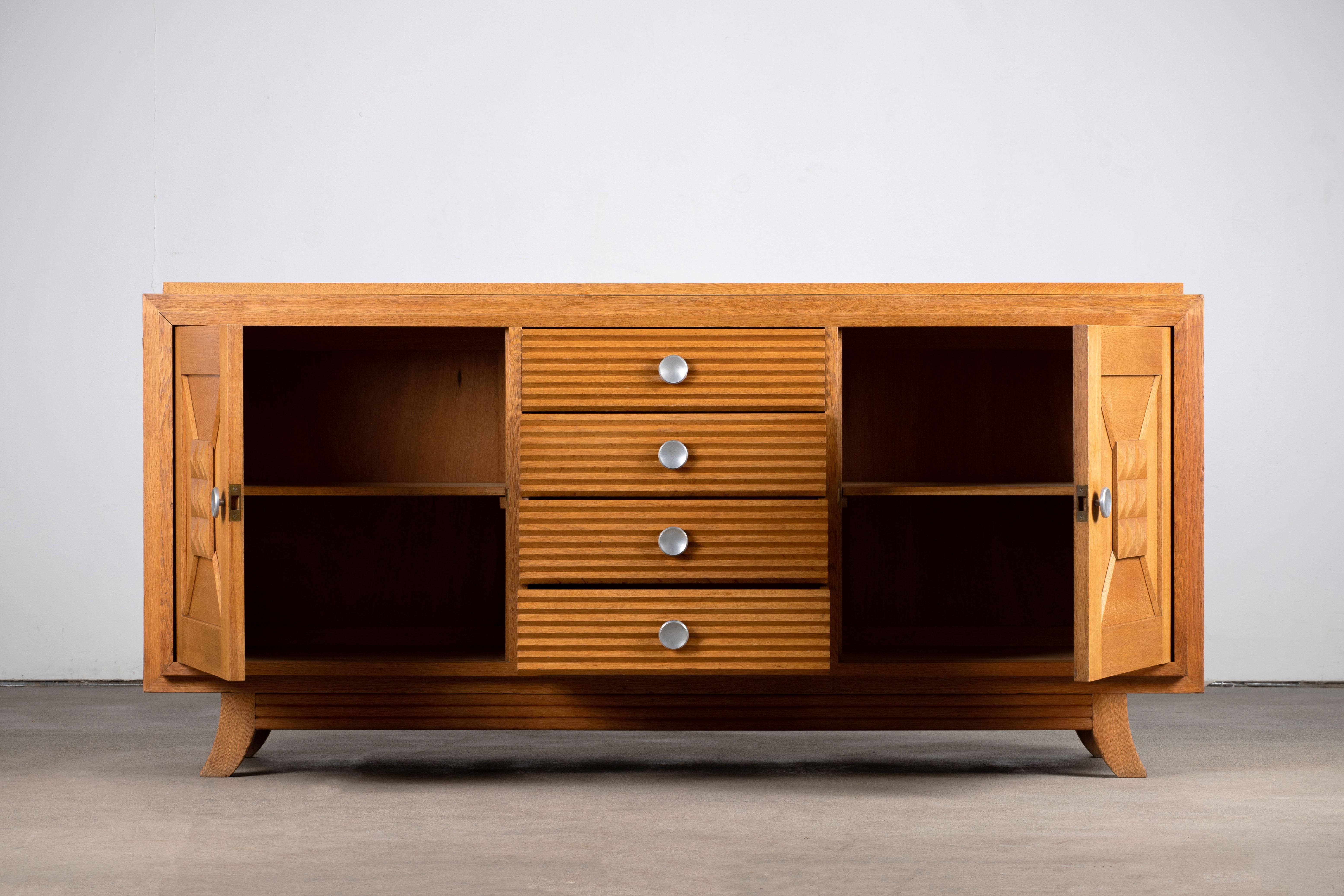 Sideboard, oak, France, 1940s
Consists of four central drawers and two storage compartments. 
The sideboard is in excellent original condition, with minor wear consistent with age and use.
A truly incredible piece in the manner of Jean Royère and