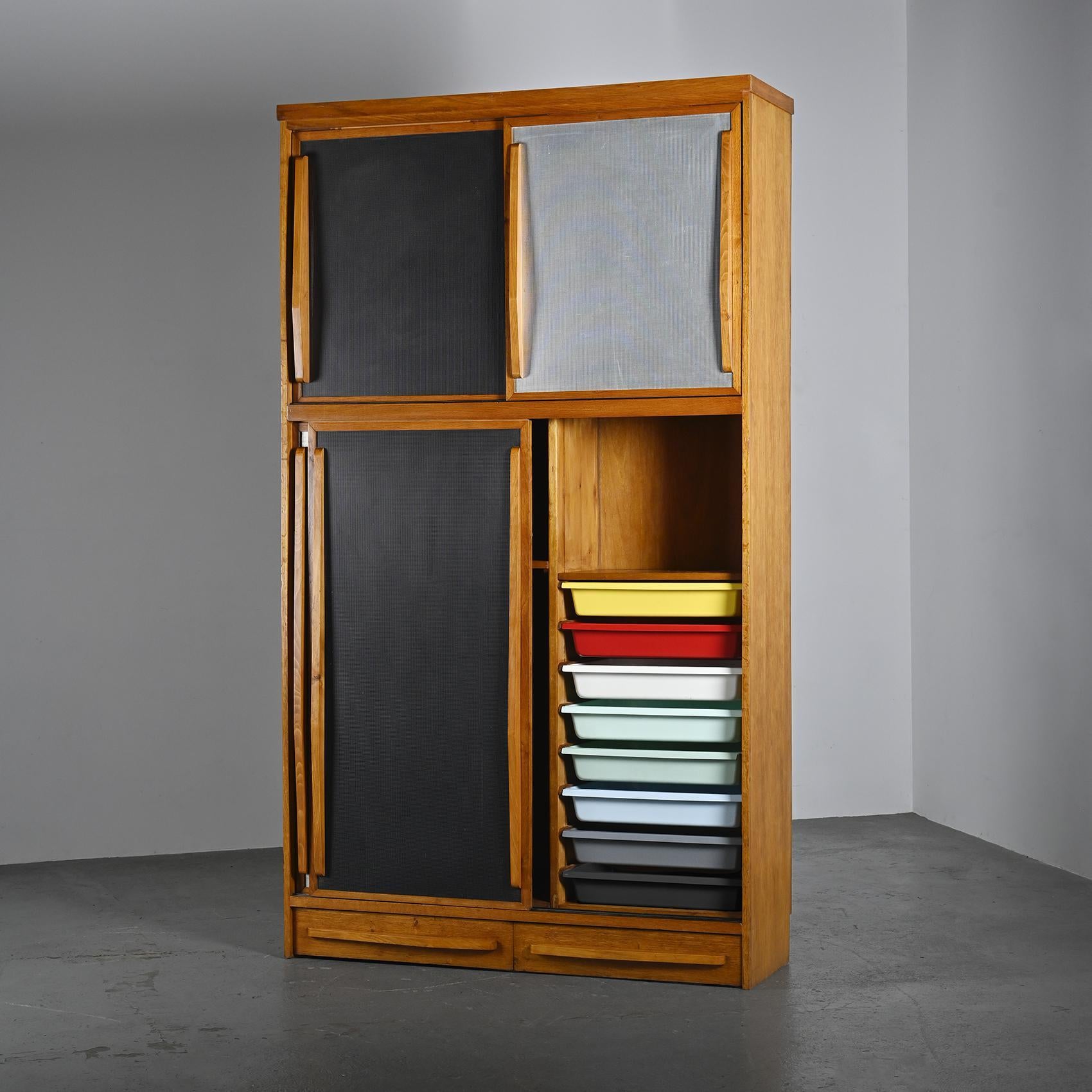 A unique piece, this cabinet embodies the vision of an architect deeply influenced by the modernist vocabulary of Jean Prouvé and Charlotte Perriand.

Crafted in solid oak, it features four sliding doors and two front drawers with sculptural,