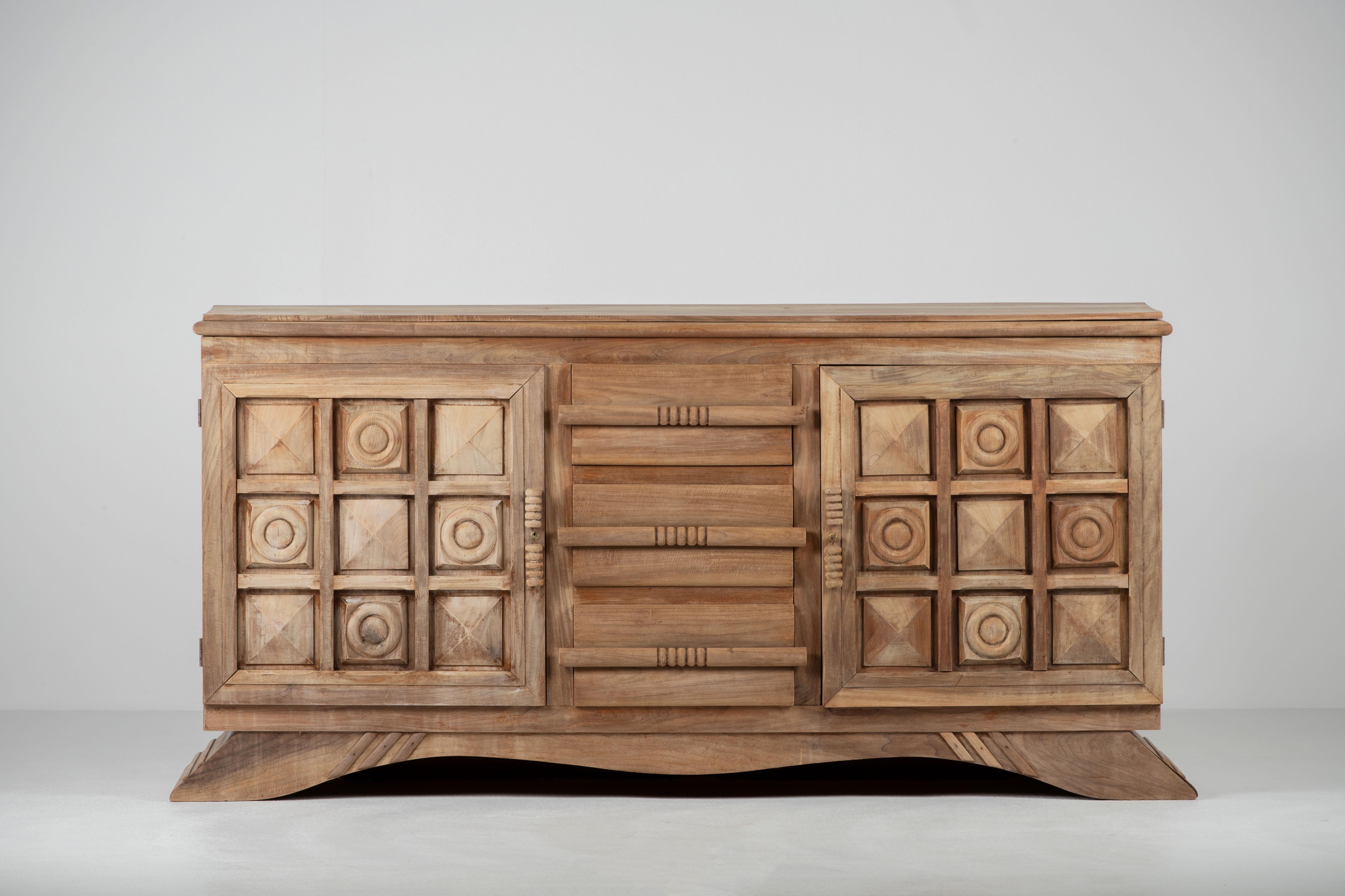 Very elegant Credenza in solid oak, France, 1940s.
Large Art Deco Brutalist sideboard. 
The credenza consists of two storage facilities and a central drawers column.
It is covered with very detailed designed doors. 
Very elegant 
The refined