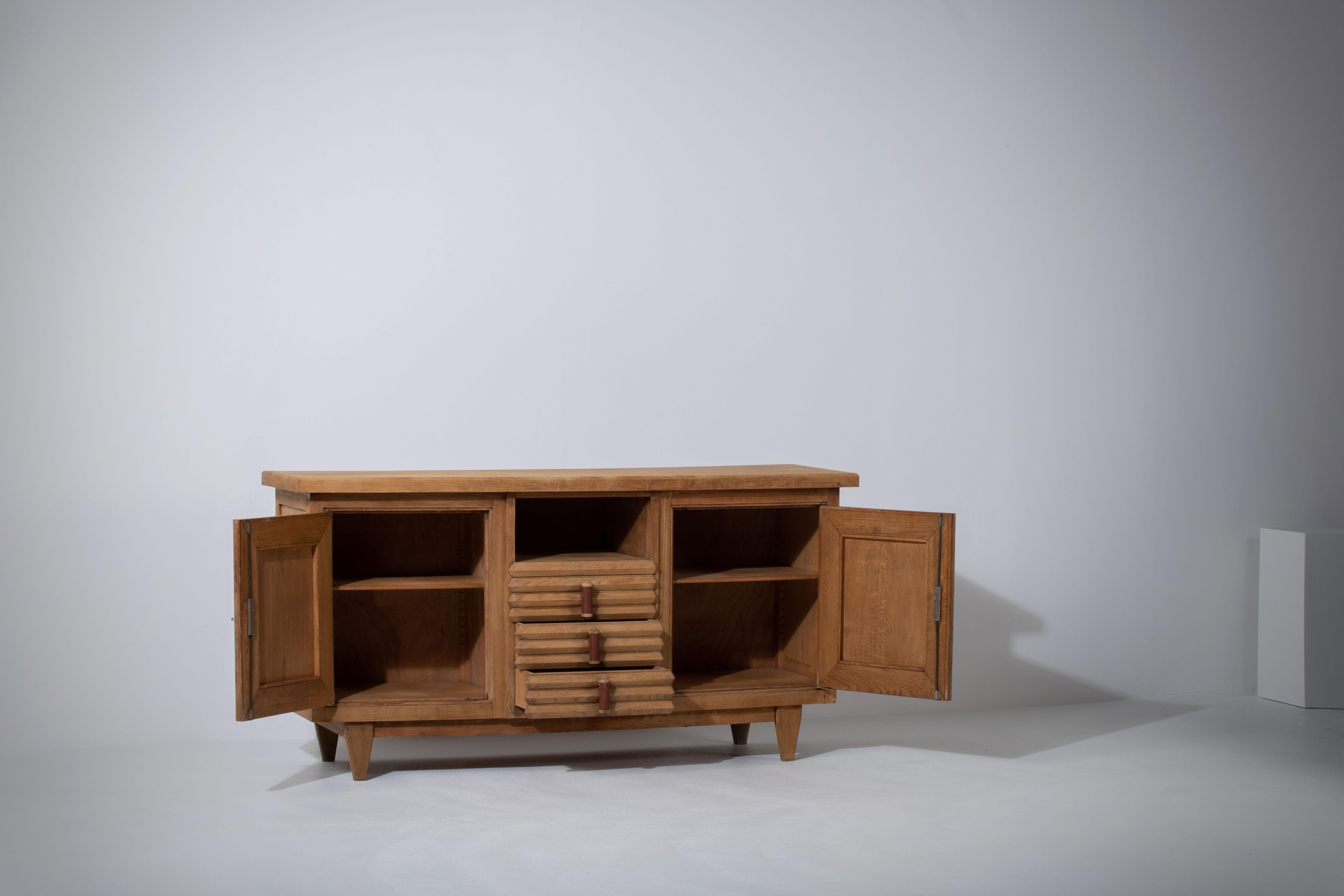Very elegant credenza in solid oak, France, 1940s.
Large Art Deco Brutalist sideboard. 
The credenza consists of three storage facilities.
It is covered with very detailed designed doors. 
Very elegant 
The refined wooden structures on the