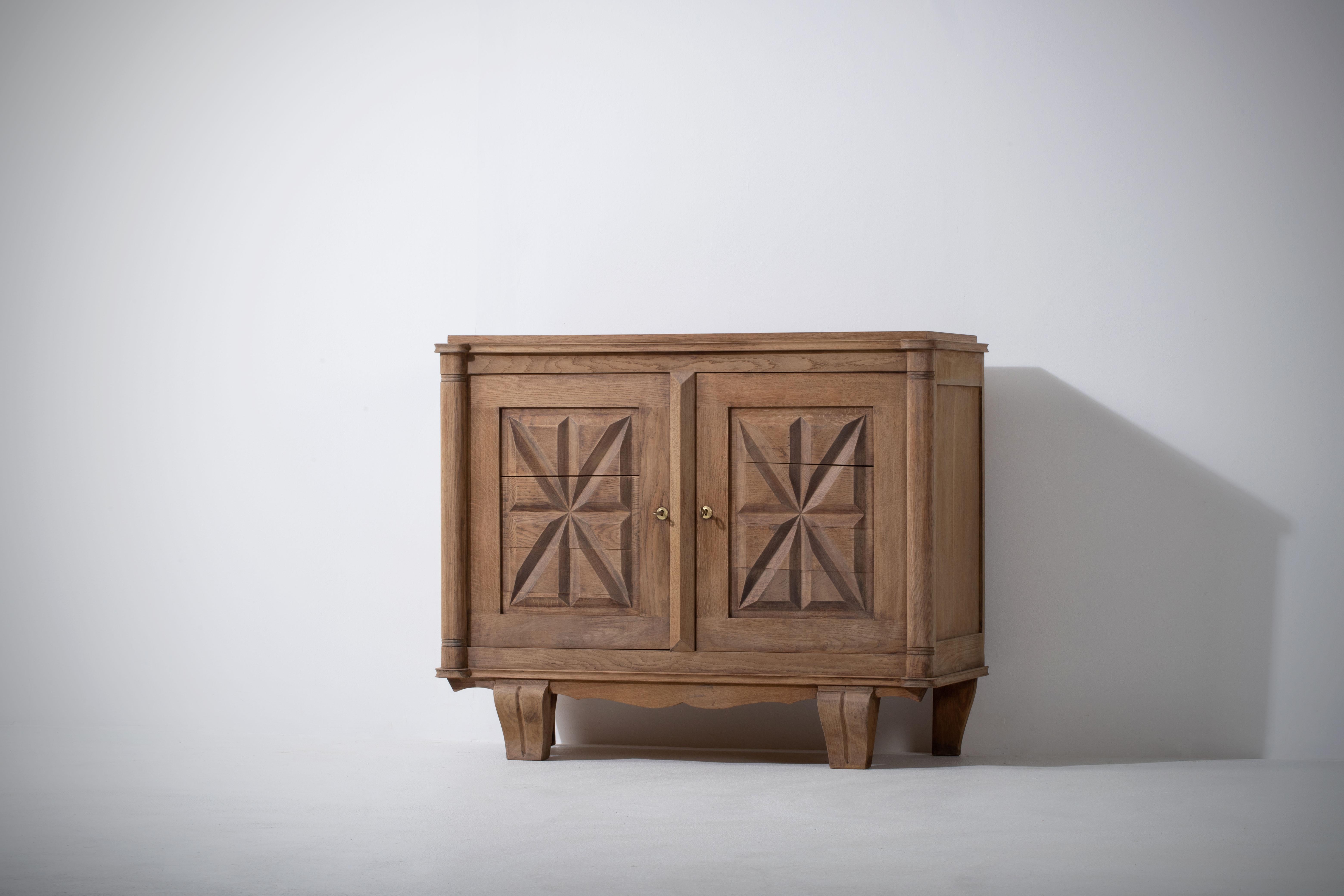 Very elegant cabinet in solid oak, France, 1940s.
The credenza consists of two storage facilities, it is covered with very detailed designed doors. 
Good vintage condition.
