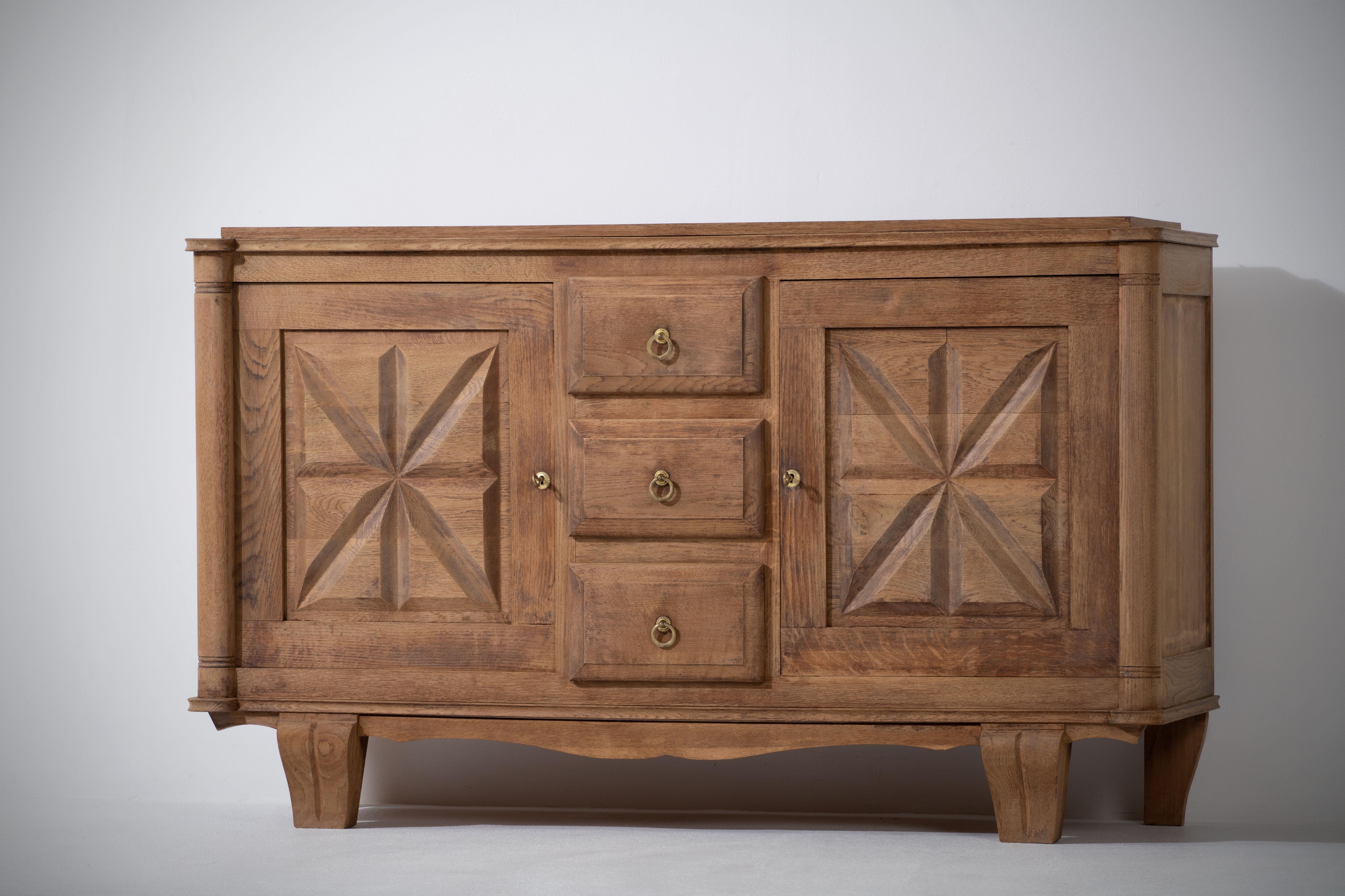 Very elegant cabinet in solid oak, France, 1940s.
The credenza consists of two storage facilities, it is covered with very detailed designed doors. 
Good vintage condition.