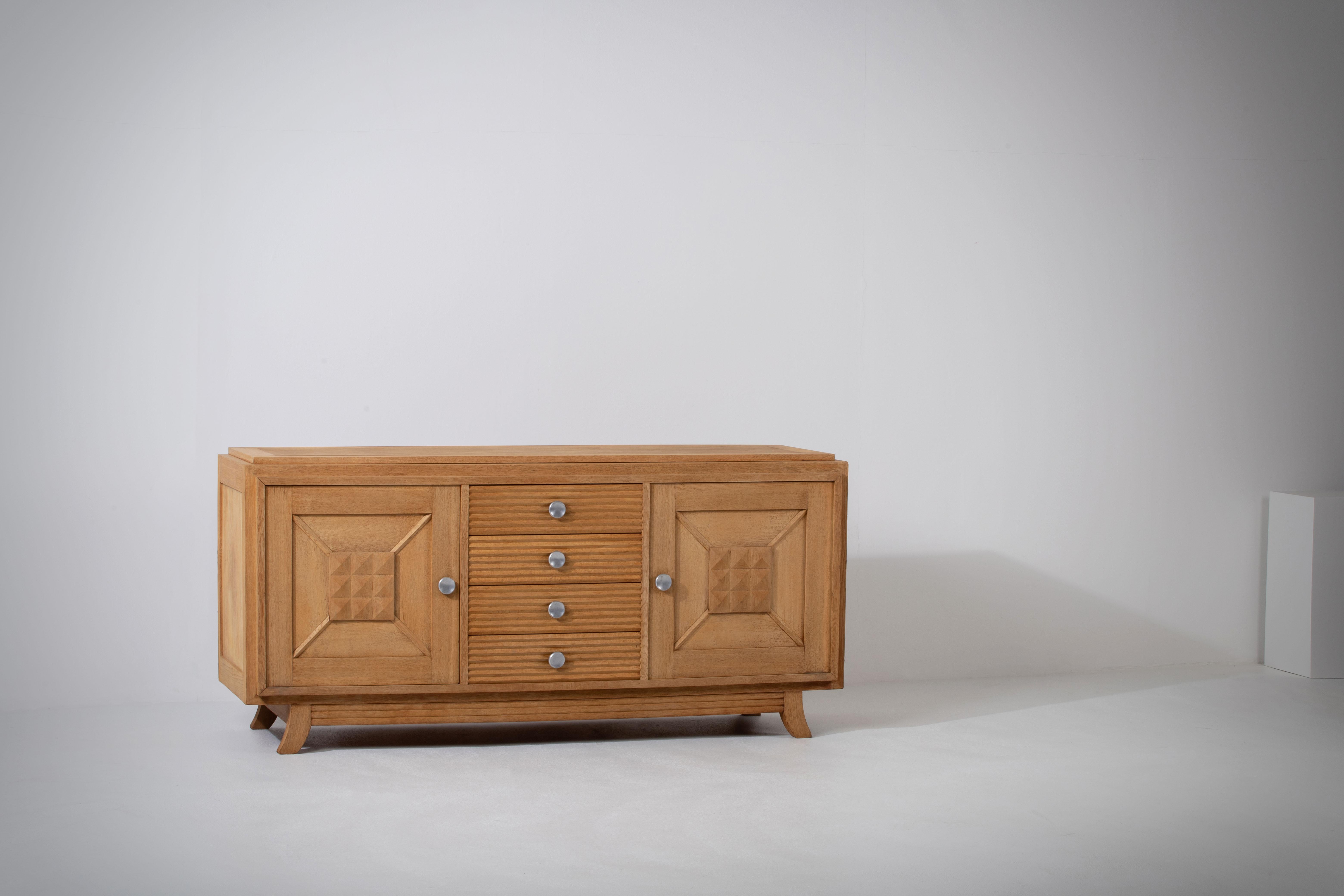 Introducing a captivating and refined 1940s Art Deco sideboard, exquisitely crafted in France from solid oak. This large and elegant credenza showcases the perfect fusion of Art Deco and Brutalist influences, making it a truly remarkable