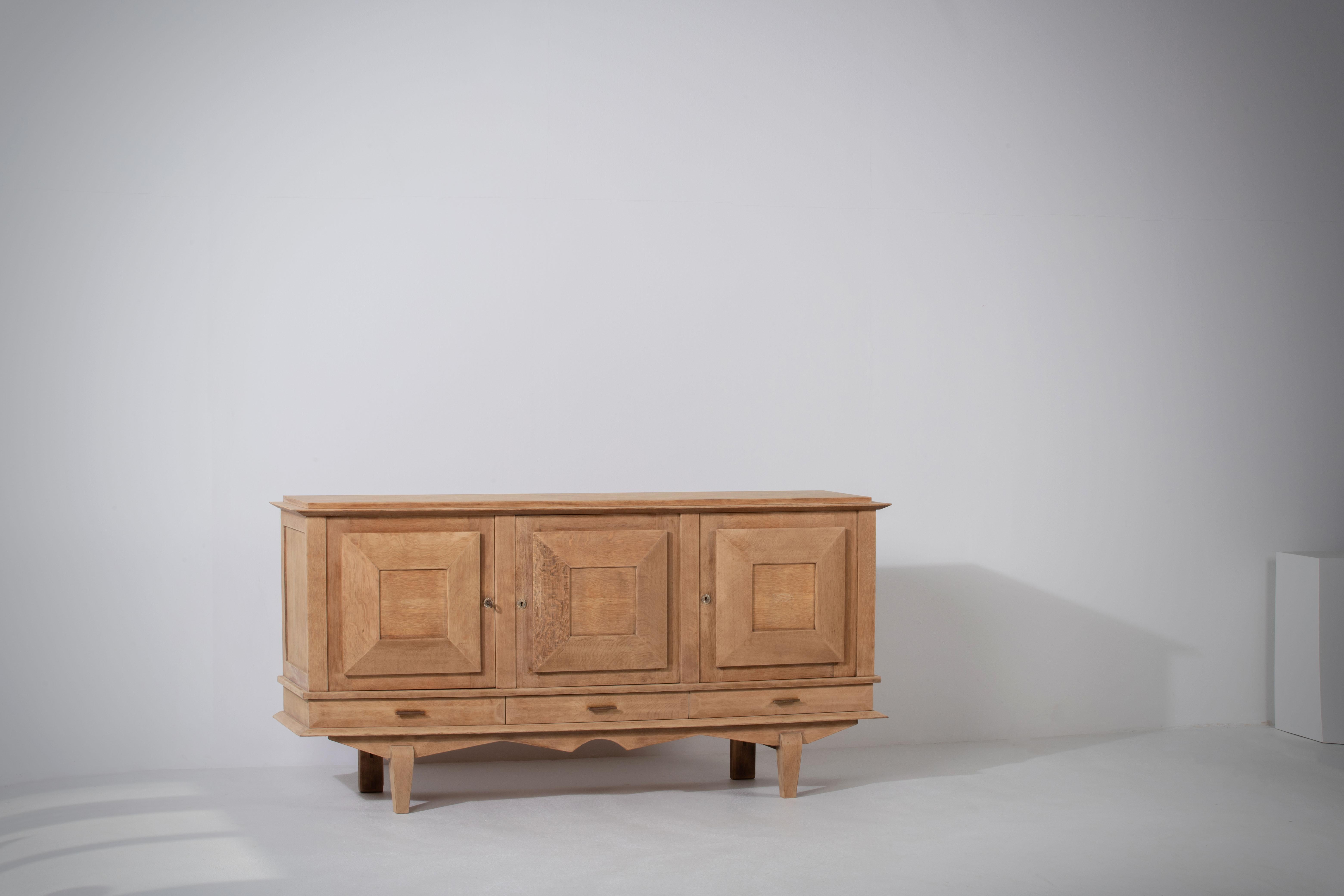 Introducing a captivating and refined 1940s Art Deco sideboard, exquisitely crafted in France from solid oak. This large and elegant credenza showcases the perfect fusion of Art Deco and Brutalist influences, making it a truly remarkable