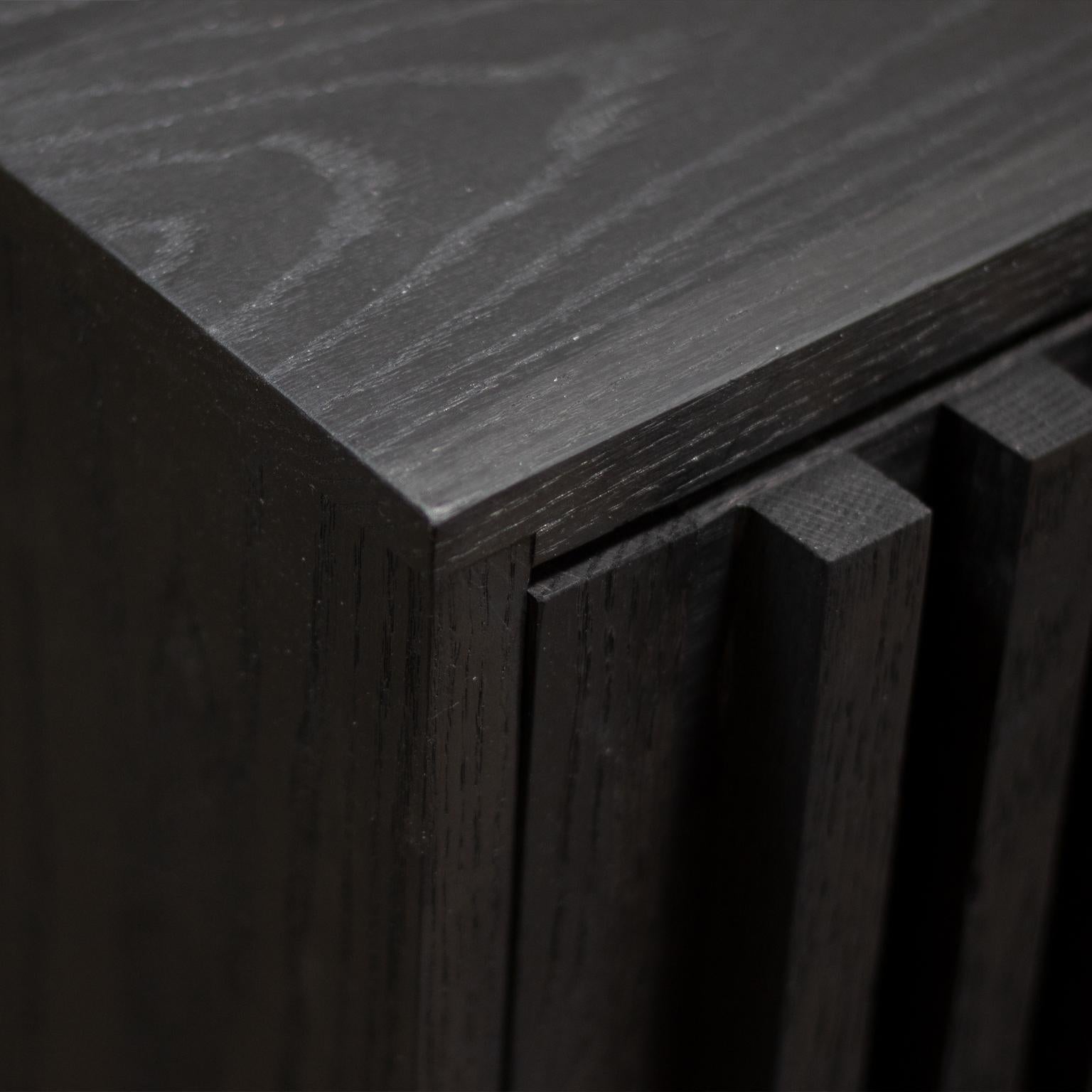 Ce meuble est construit en bois de chêne entièrement massif, avec une finition à l'encre de Chine et à la cire d'abeille. 
Pieds réglables en acier revêtu de poudre et quincaillerie d'étagère réglable en laiton. 

Personnalisable.