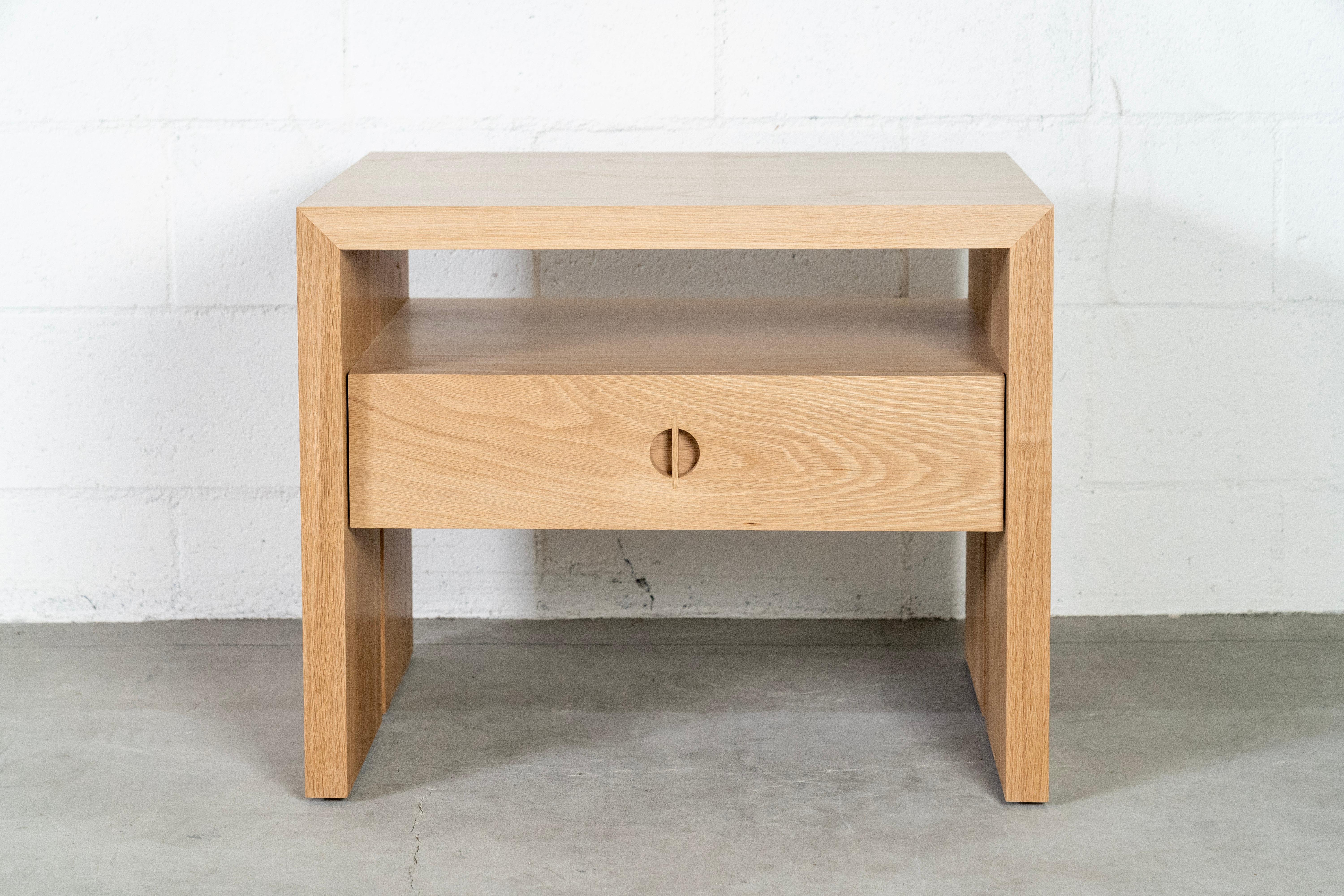 Questo comodino personalizzato con cassetto è realizzato a mano negli Stati Uniti con una struttura interamente in legno duro. Caratterizzato da un sorprendente design a cascata, dall'esclusivo dettaglio dell'intarsio in noce e dal comodo e