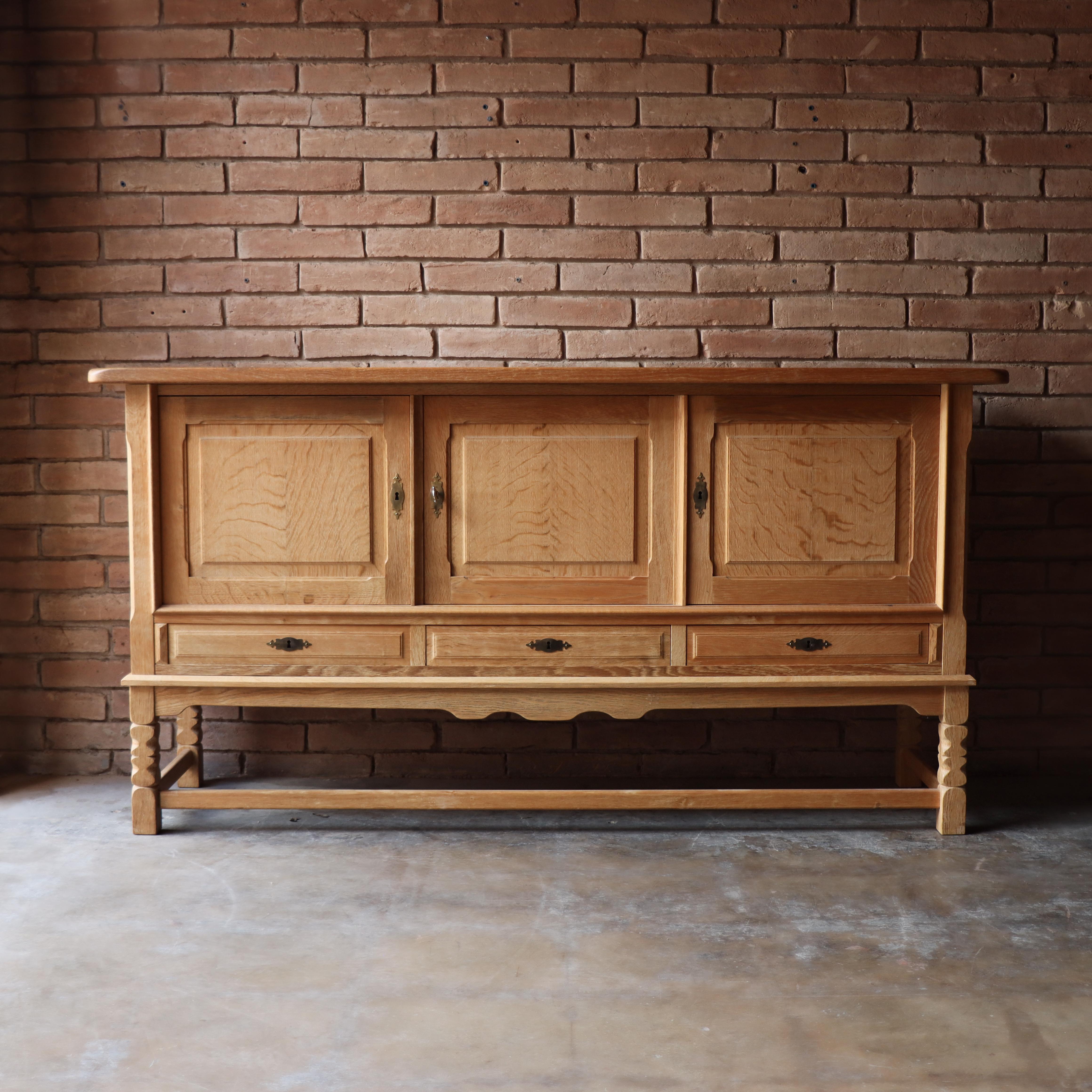 Beautiful solid oak sideboard/credenza attributed to Henning Kjærnulf, Denmark -1960s.  This beautiful example is constructed of nothing but solid quarter-sewn white oak. The cabinet front features excellent attention to refined details. 

This
