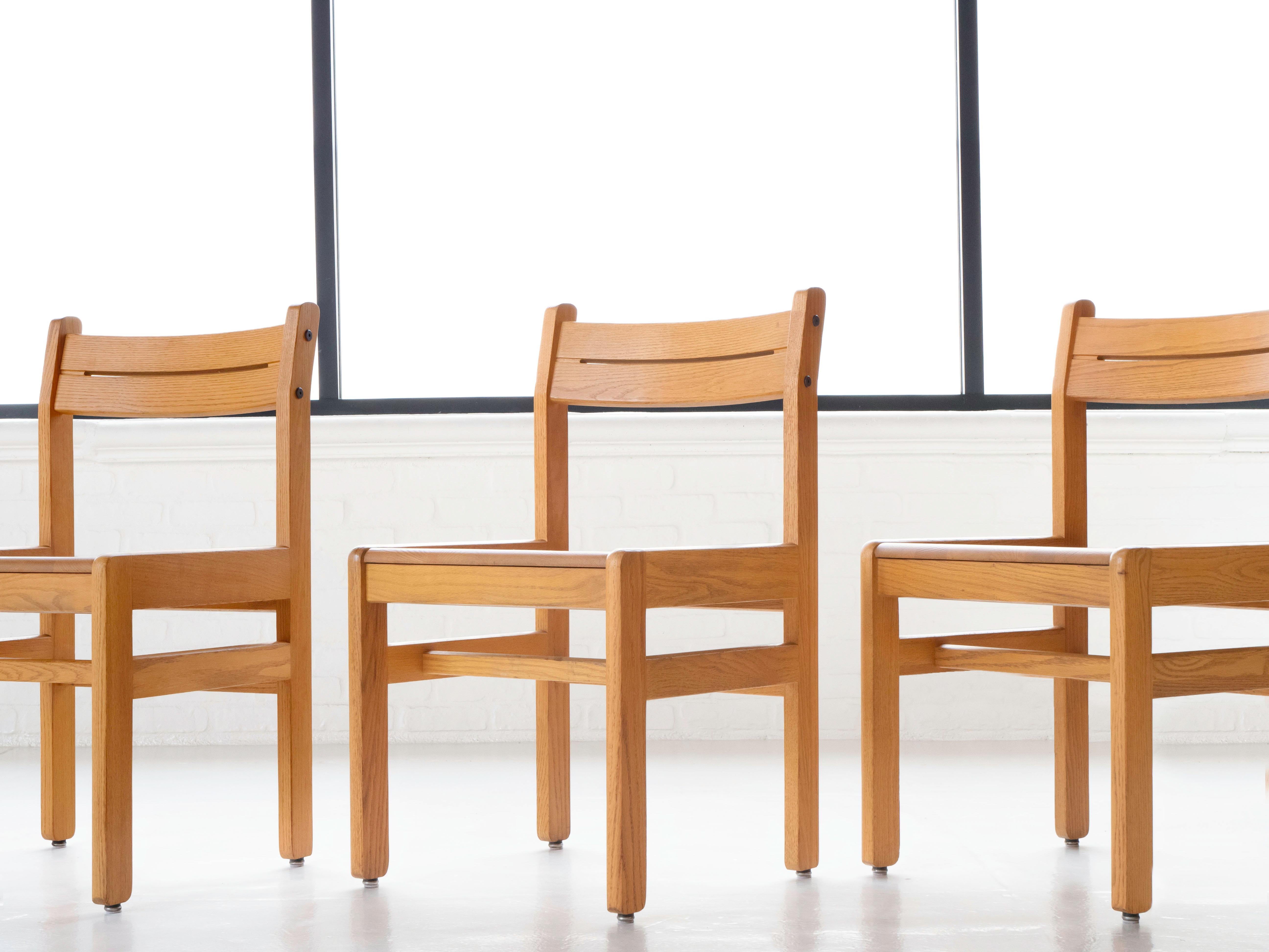 Ensemble de neuf chaises de bibliothèque de style français post-moderne entièrement en chêne massif. Fabriqué vers les années 1990. Chaque chaise a été légèrement nettoyée et se trouve dans son état d'origine, présentant une légère patine. Tous sont