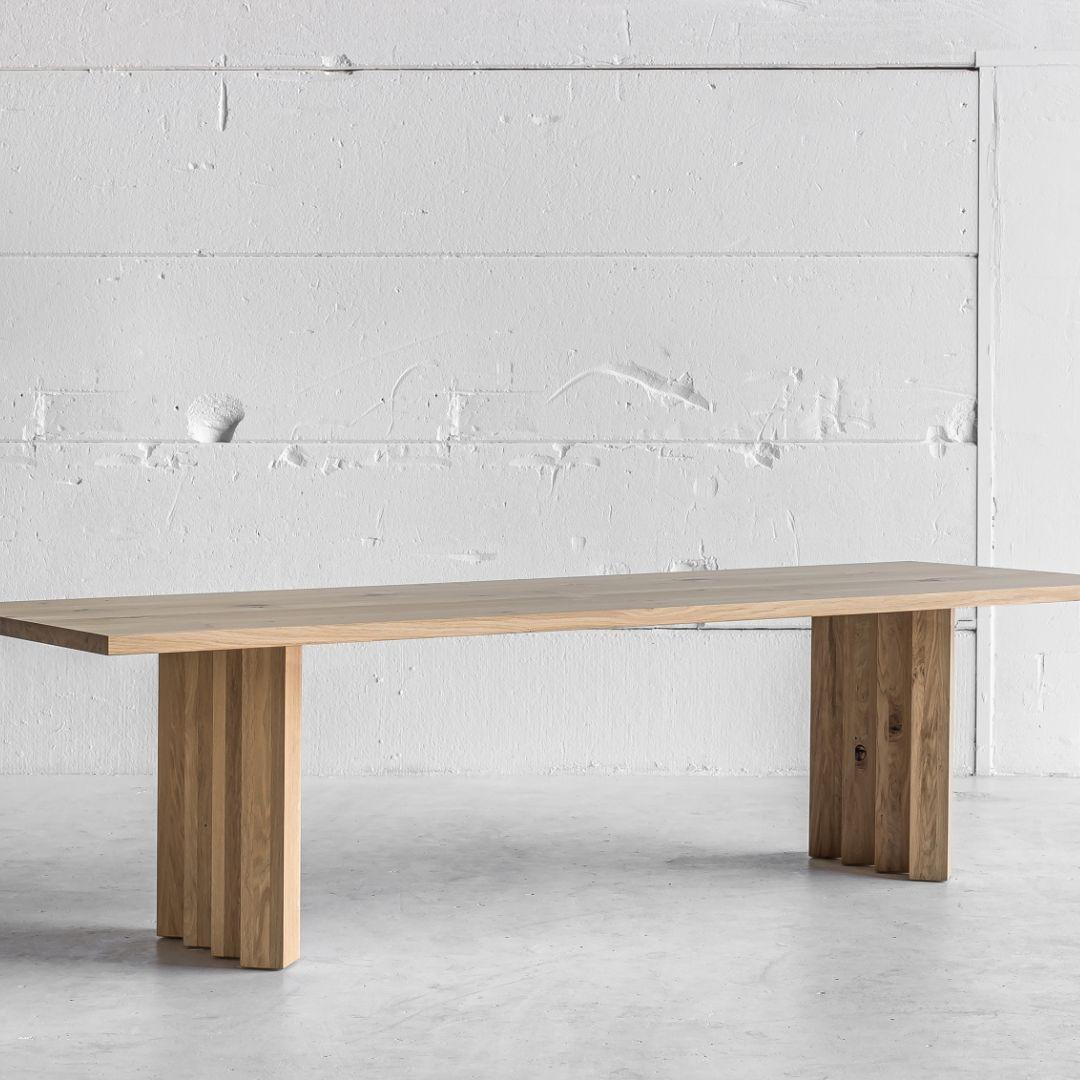 Cette table de salle à manger sculpturale mais minimaliste incarne la sophistication européenne moderne et l'élégance intemporelle. 

Fabriqué à la main en chêne massif, le plateau de la table a une forme rectangulaire simple avec une épaisseur de 4