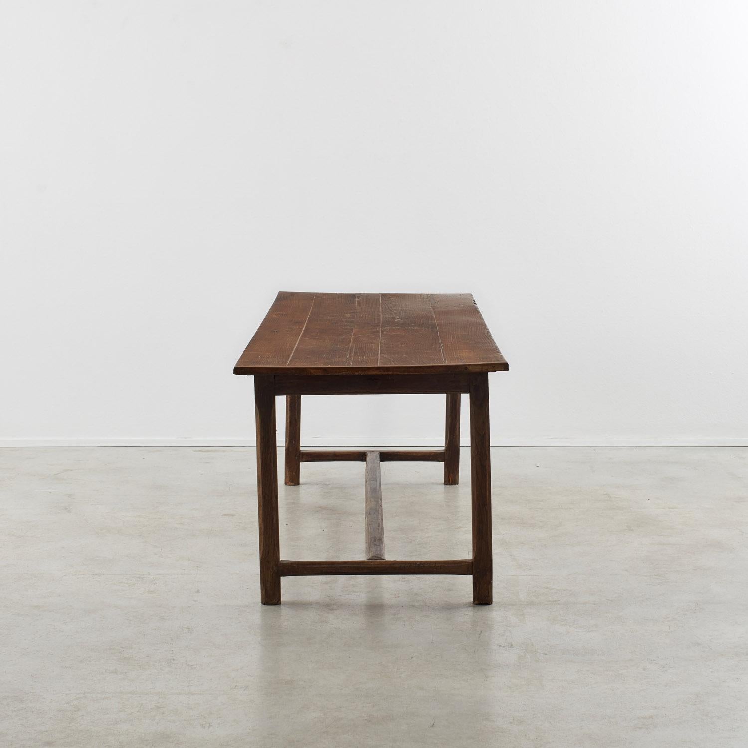 Riche d'un caractère honnête, cette table de réfectoire en chêne antique peut accueillir huit personnes. Le plateau de table en planches clivées repose sur quatre pieds carrés chanfreinés, dont l'intégrité structurelle est renforcée par une traverse