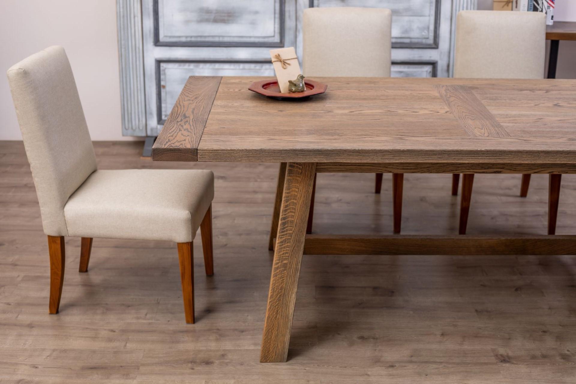 The subtle angles of this solid oak table provide a refined rustic elegance that makes it a genuinely approachable design. The sloped legs and solid natural wood highlight the hand-crafted mortise and tenon joinery and an intricate French Country