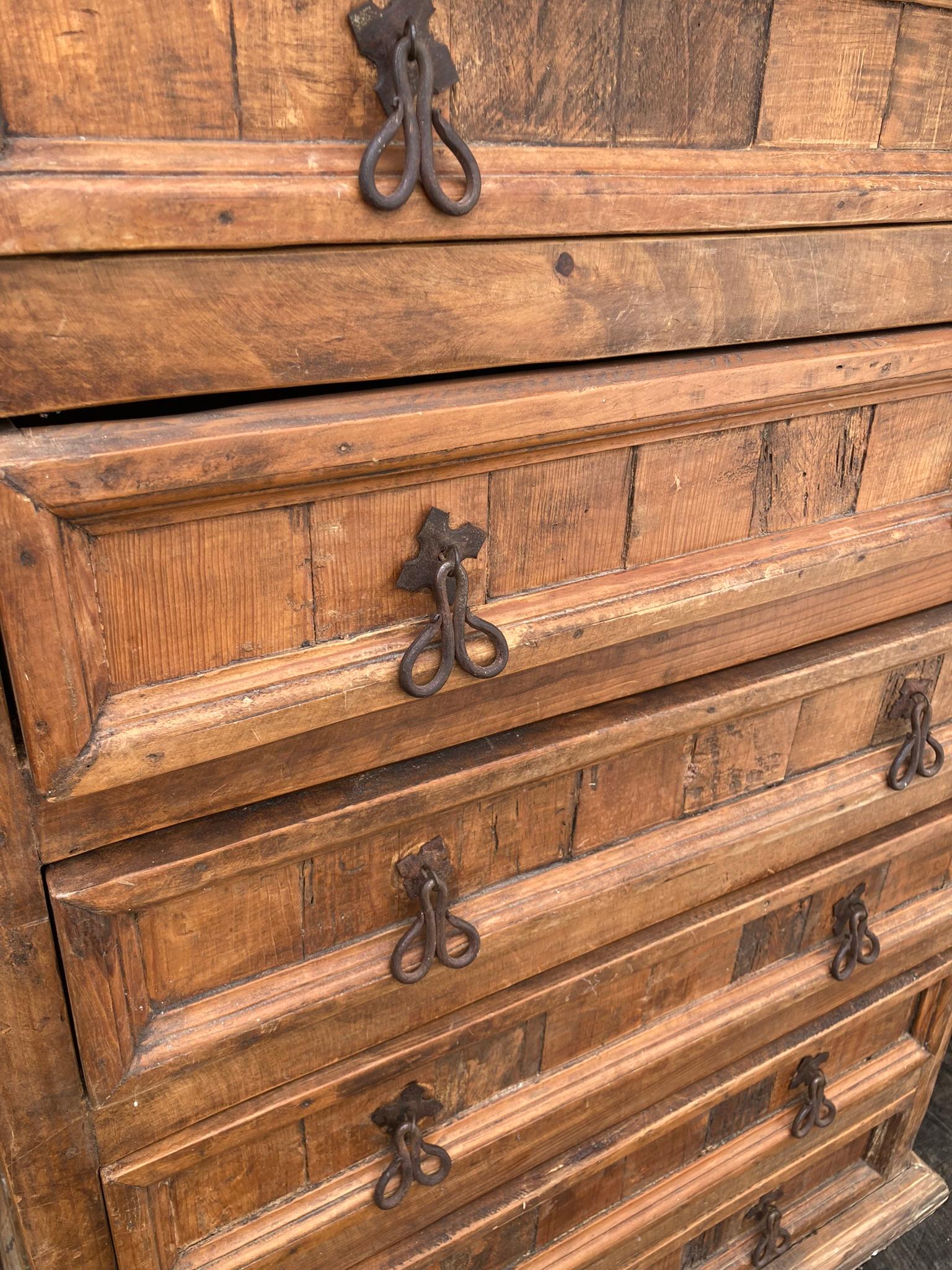 Solid Oak Tall Boy or High Chest, 7 Large Drawers, possibly Spanish Mid Century with cast iron handles. A practical and imposing piece of furniture built to last for centuries. A rustic look with antique charm.

H: 130cm

W: 84cm

D: 46cm