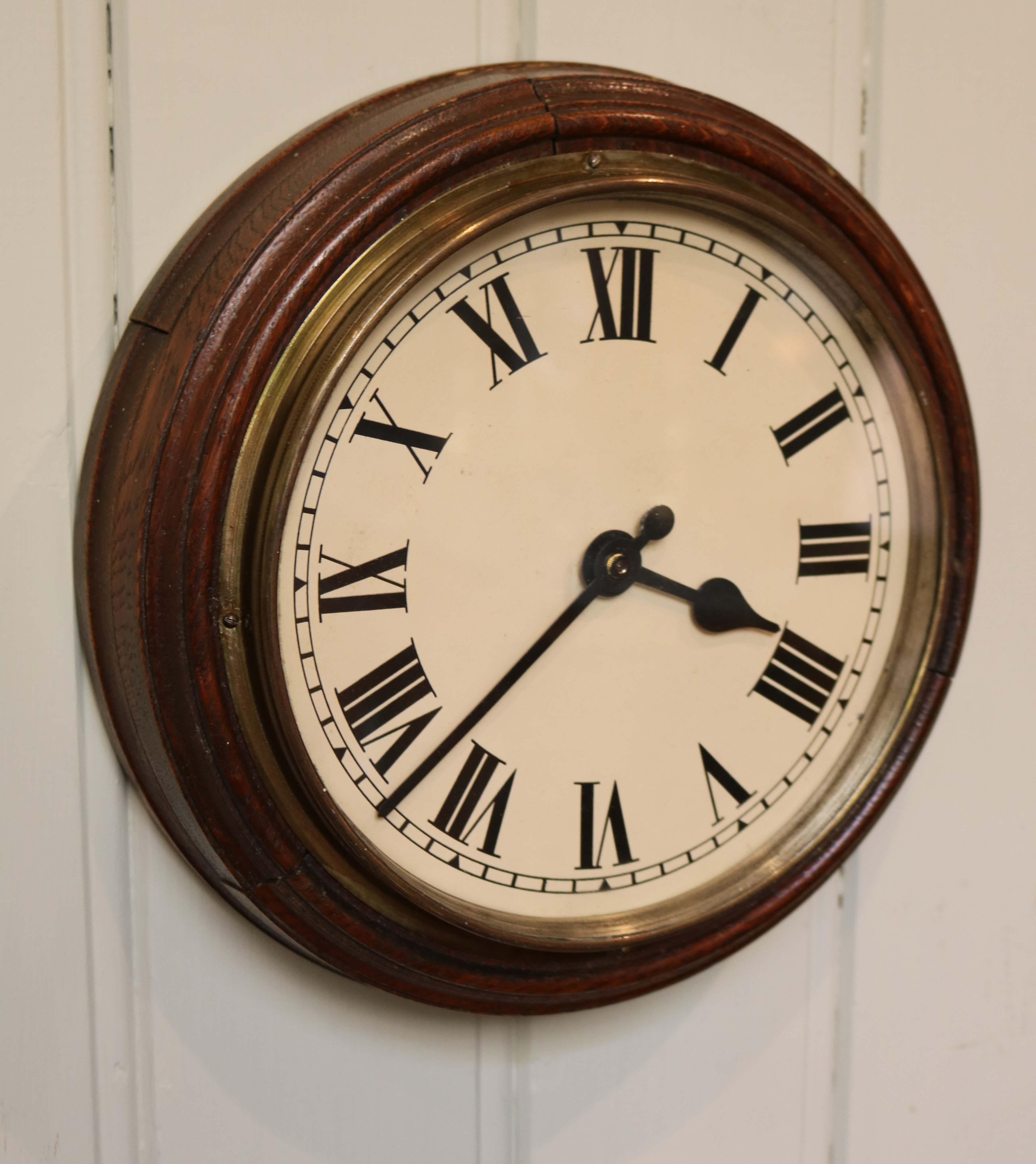 A solid oak school clock, dating to the early 20th Century removed from a Scottish school during conversion. Originally an electrically powered slave clock driven from a master clock. It has its original painted dial and hands, a sectional solid oak