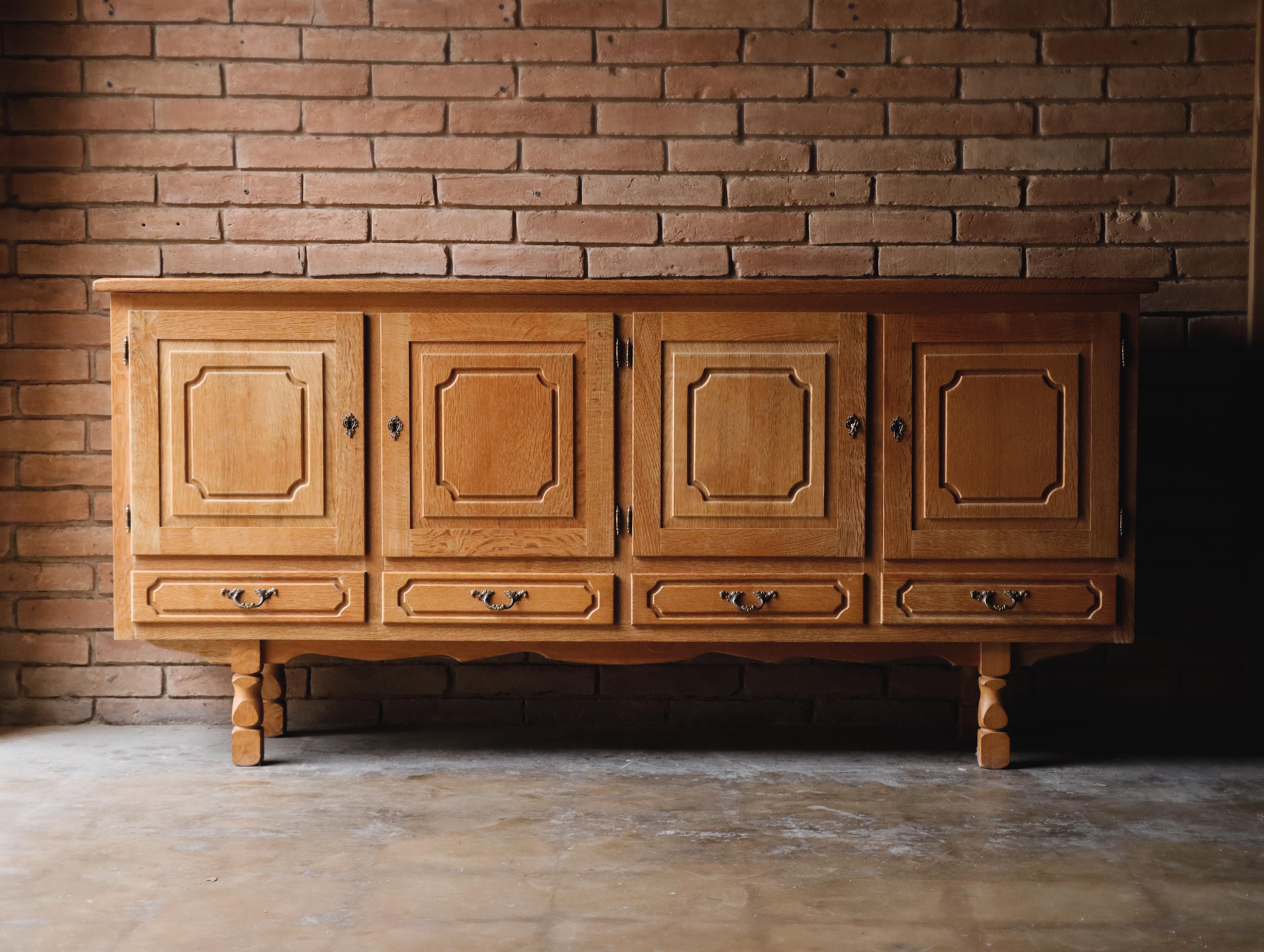 Buffet en chêne massif danois fabriqué à la main et attribué à Henning Kjaernulf, connu pour ses créations sculpturales qui fusionnent artisanat traditionnel et modernisme. Vers les années 1970, 

Il se compose de panneaux en chêne cousus sur