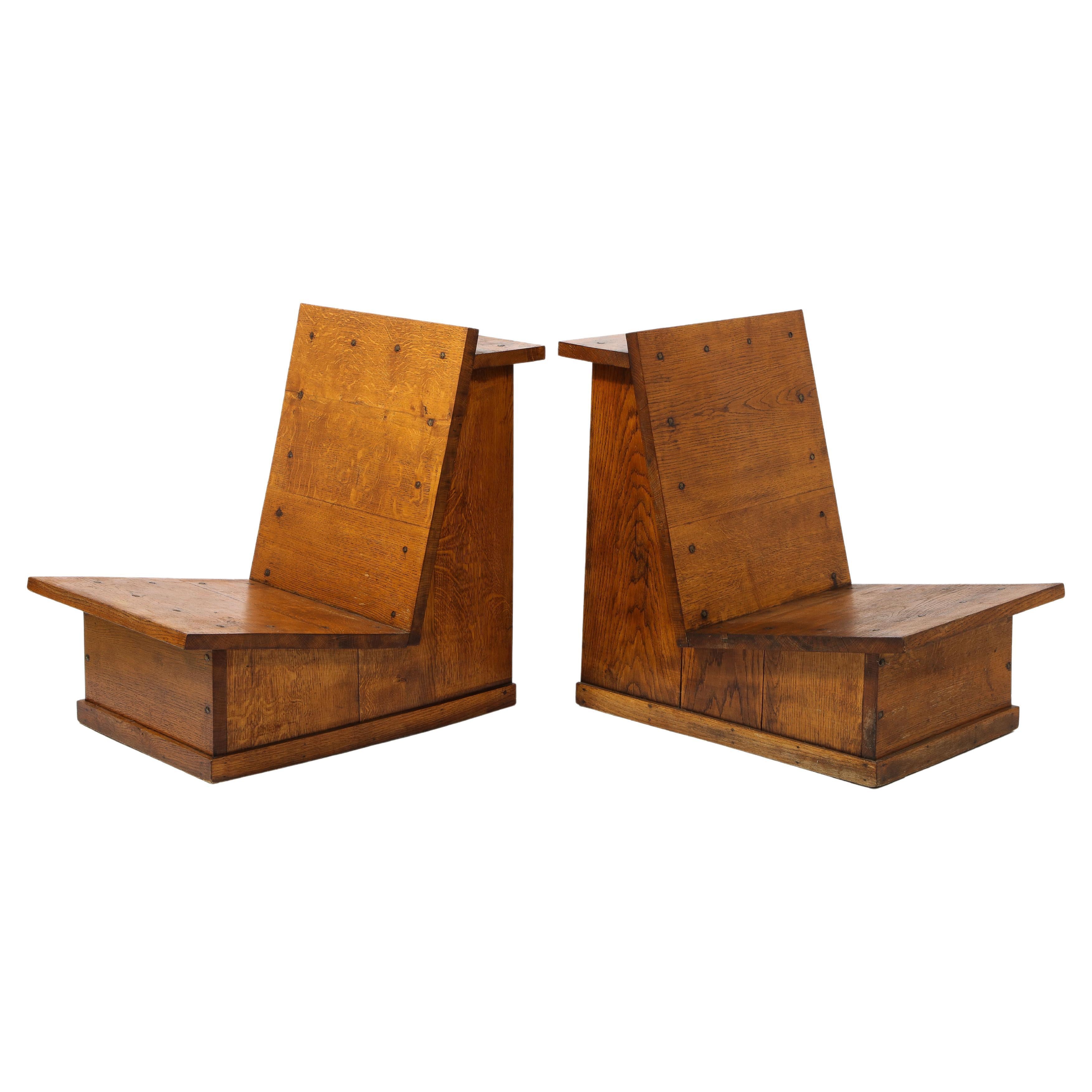 A pair of Brutalist slipper chairs of the Jura region of France, reminiscent of the furniture used in ski resorts by Perriand, these chairs are constructed with solid oak planks and wrought iron nails.