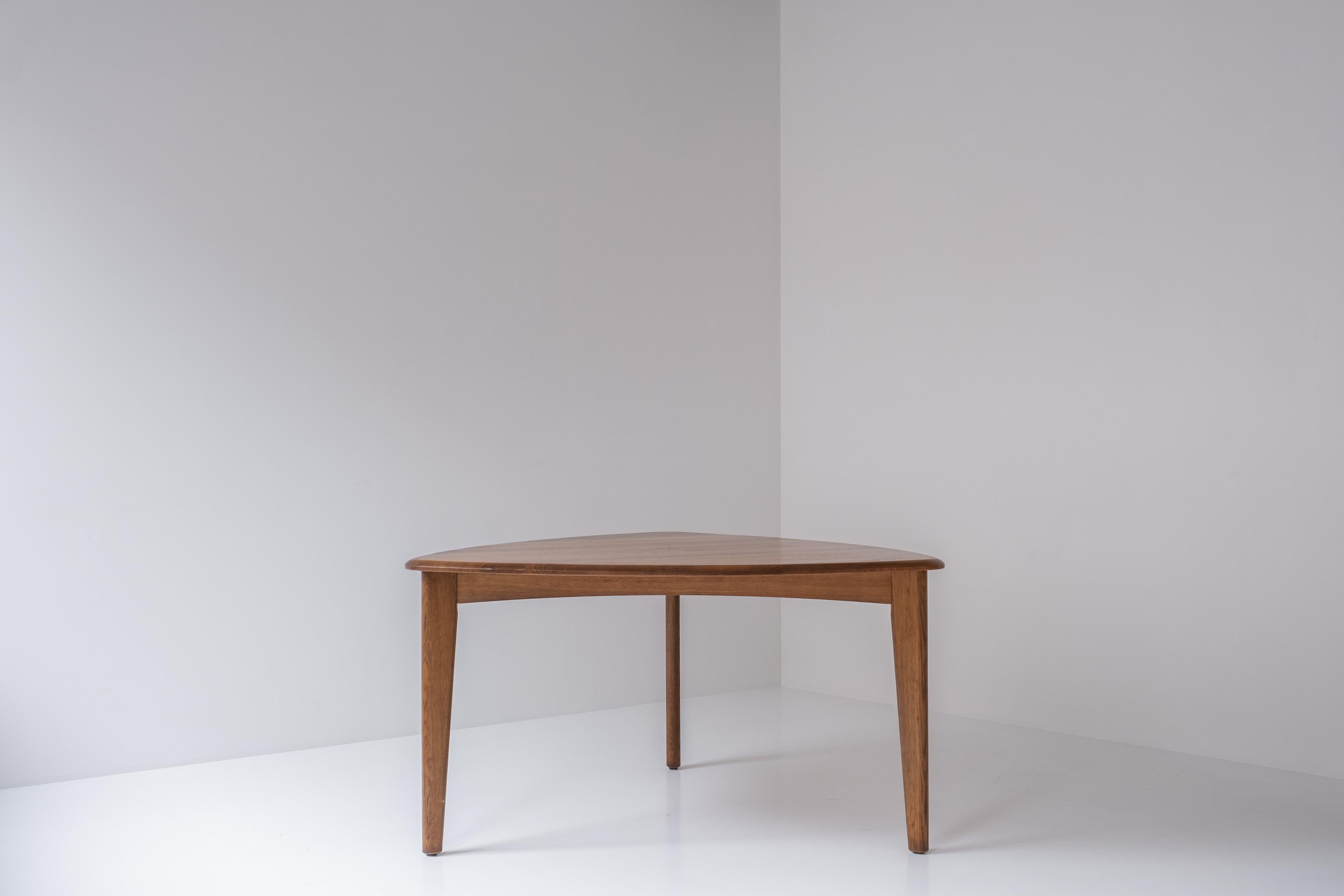 Lovely dining table from France, designed in the 1950s. This solid oak dining table has a triangle shaped top which gives its design a very modern touch. Suits up for 6 persons easily (2 chairs each side). Definitely inspired by the works Pierre