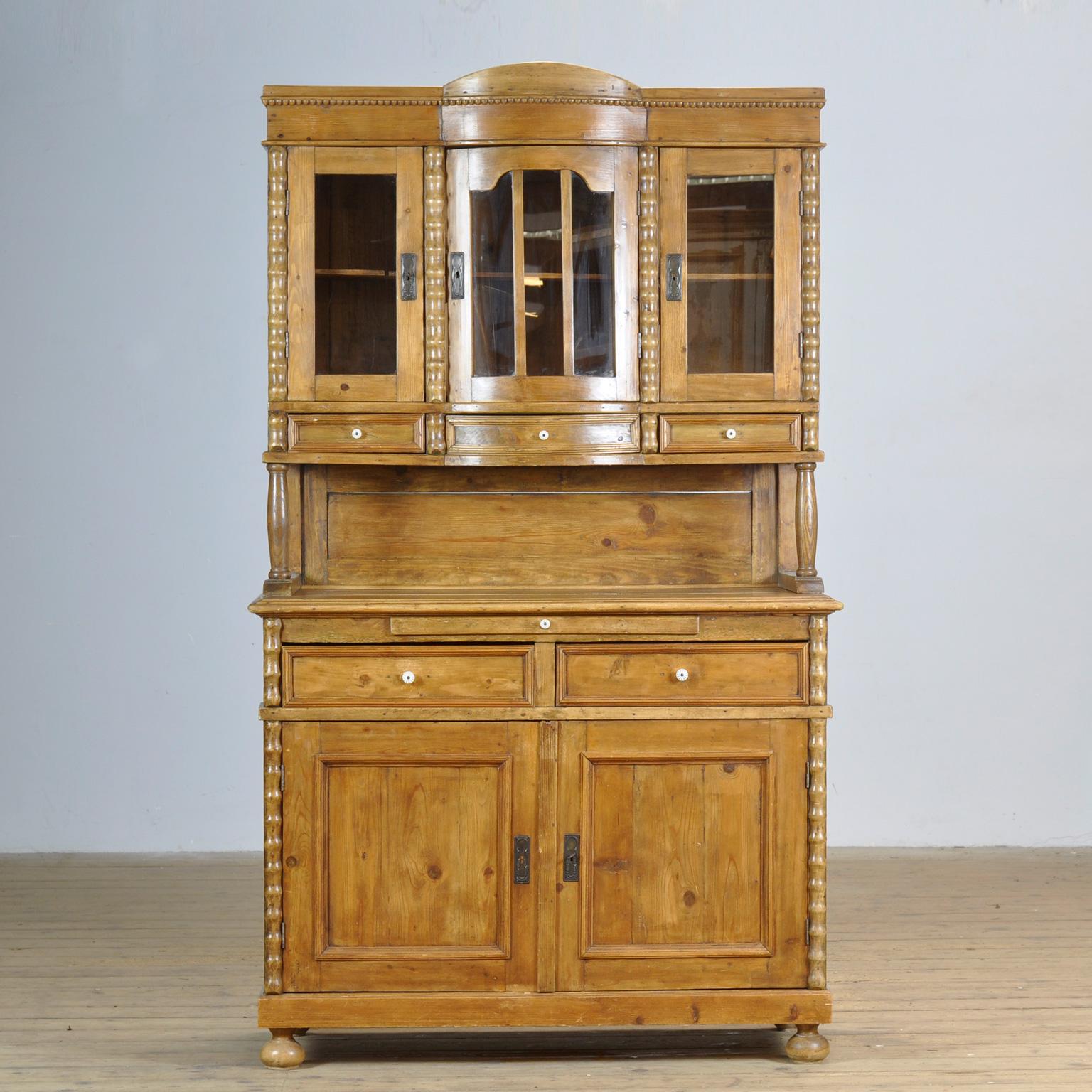 Antique German solid pine bread cabinet from circa 1925. The cabinet has a curved front with an extendable shelf for cutting bread. Lots of storage space behind the 5 doors. Assembled with dovetail joints.
The cabinet consists of two separate parts