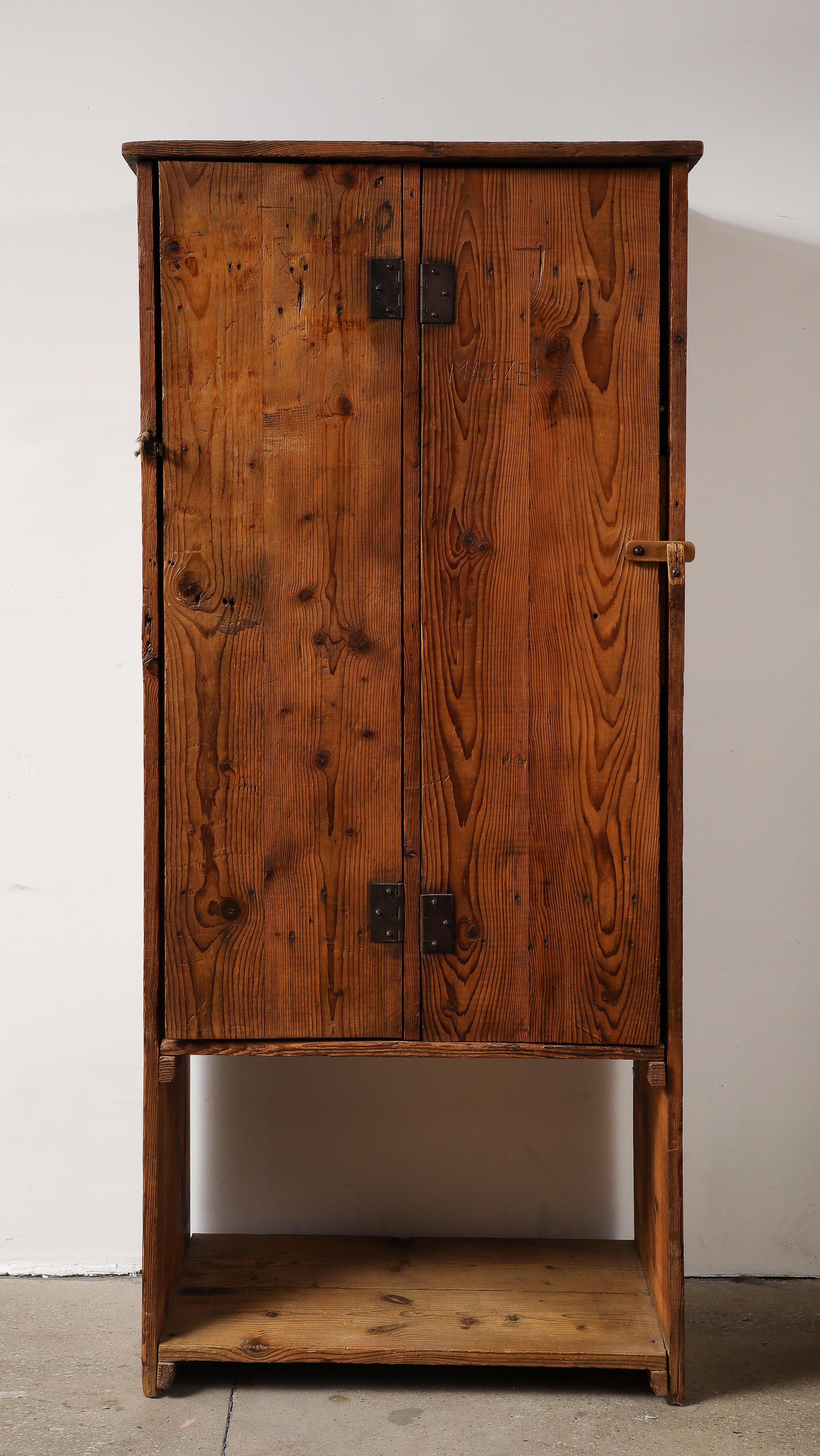 This charming hand made cabinet was made during the post war time where materials were scarce and wood became one of the few materials to use.  It is from Auvergnat France, and has a whimsy and glimpse into life at the time with pegs to hand smocks