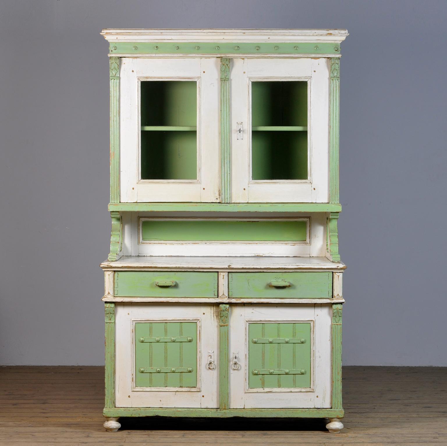 Large pine cupboard from the 1920s. The cabinet consists of 2 separate parts. In the upper part 2 doors with one shelf. At the bottom 2 drawers above and 2 doors with a shelf for plenty of storage space. Original paint.