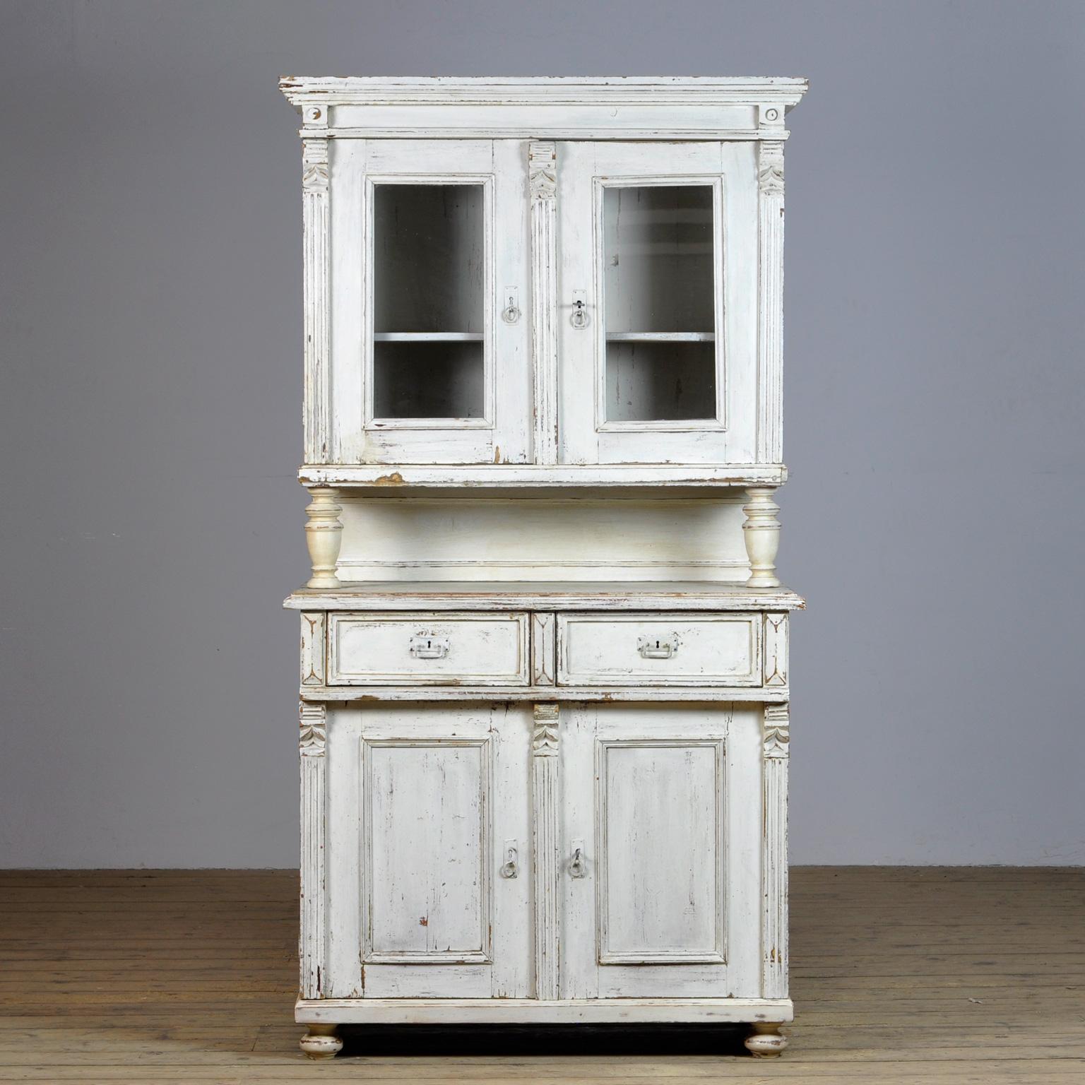 Large pine cupboard from the 1920s. The cabinet consists of 2 separate parts. In the upper part 2 doors with one shelf. At the bottom 2 drawers above and 2 doors with a shelf for plenty of storage space. Original paint.