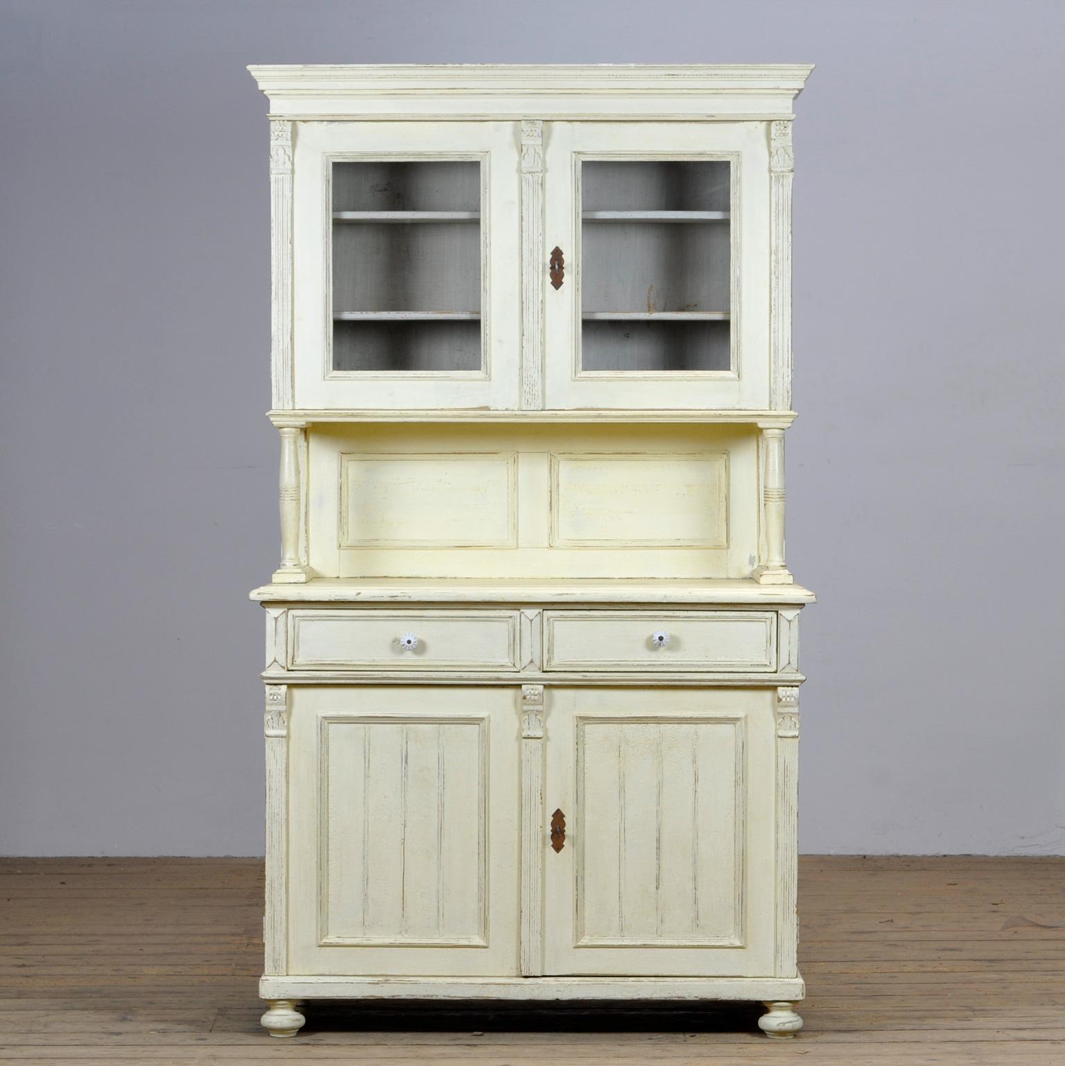 Large pine cupboard from the 1920s. The cabinet consists of 2 separate parts. In the upper part 2 doors with two shelves. At the bottom 2 drawers above and 2 doors with a shelf for plenty of storage space. Original paint.