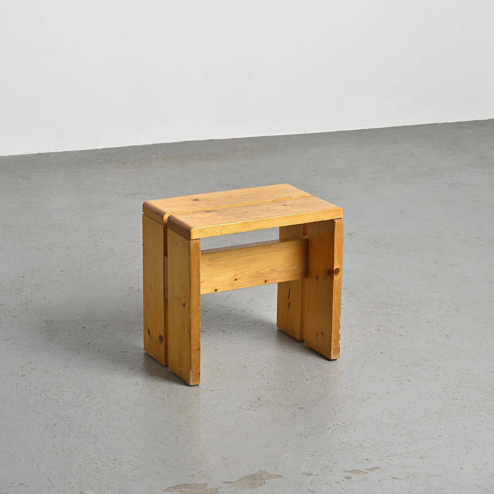 Diese mit Präzision aus massivem Kiefernholz gefertigten Hocker haben eine elegante umgekehrte U-Form und eine charmante Patina. Diese Hocker wurden speziell als Modell für das Skigebiet Les Arcs 1800 ausgewählt, wo Charlotte Perriand 20 Jahre lang