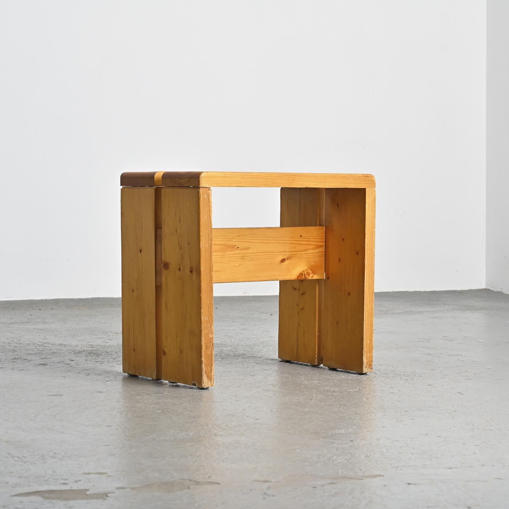 Diese mit Präzision aus massivem Kiefernholz gefertigten Hocker haben eine elegante umgekehrte U-Form und eine charmante Patina. Diese Hocker wurden speziell als Modell für das Skigebiet Les Arcs 1800 ausgewählt, wo Charlotte Perriand 20 Jahre lang