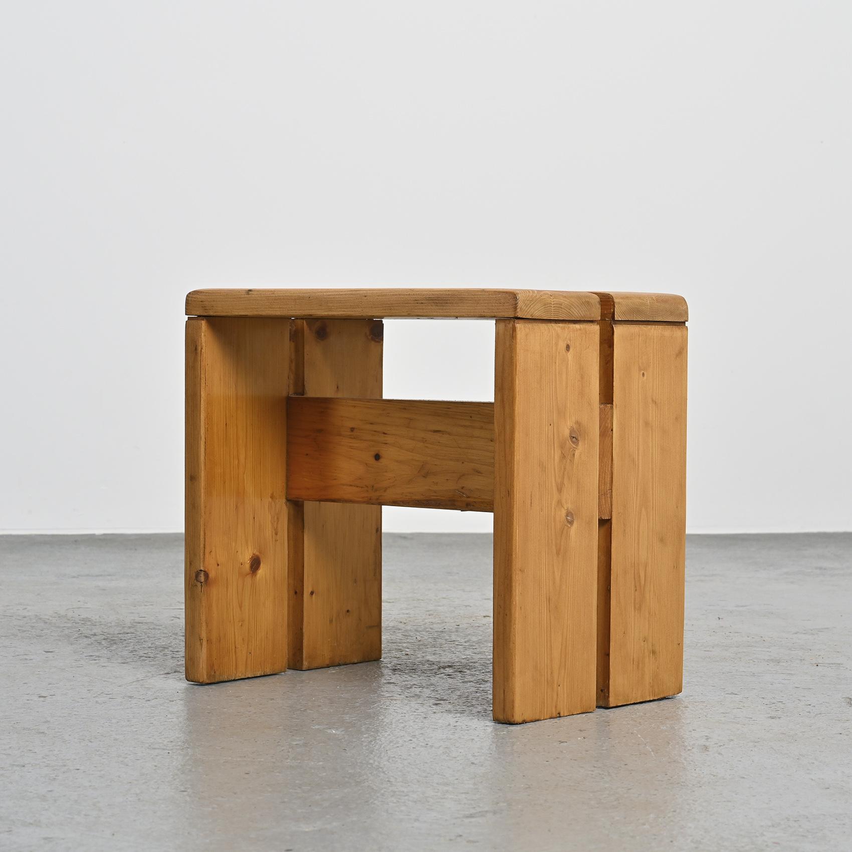 Diese mit Präzision aus massivem Kiefernholz gefertigten Hocker haben eine elegante umgekehrte U-Form und eine charmante Patina. Diese Hocker wurden speziell als Modell für das Skigebiet Les Arcs 1800 ausgewählt, wo Charlotte Perriand 20 Jahre lang