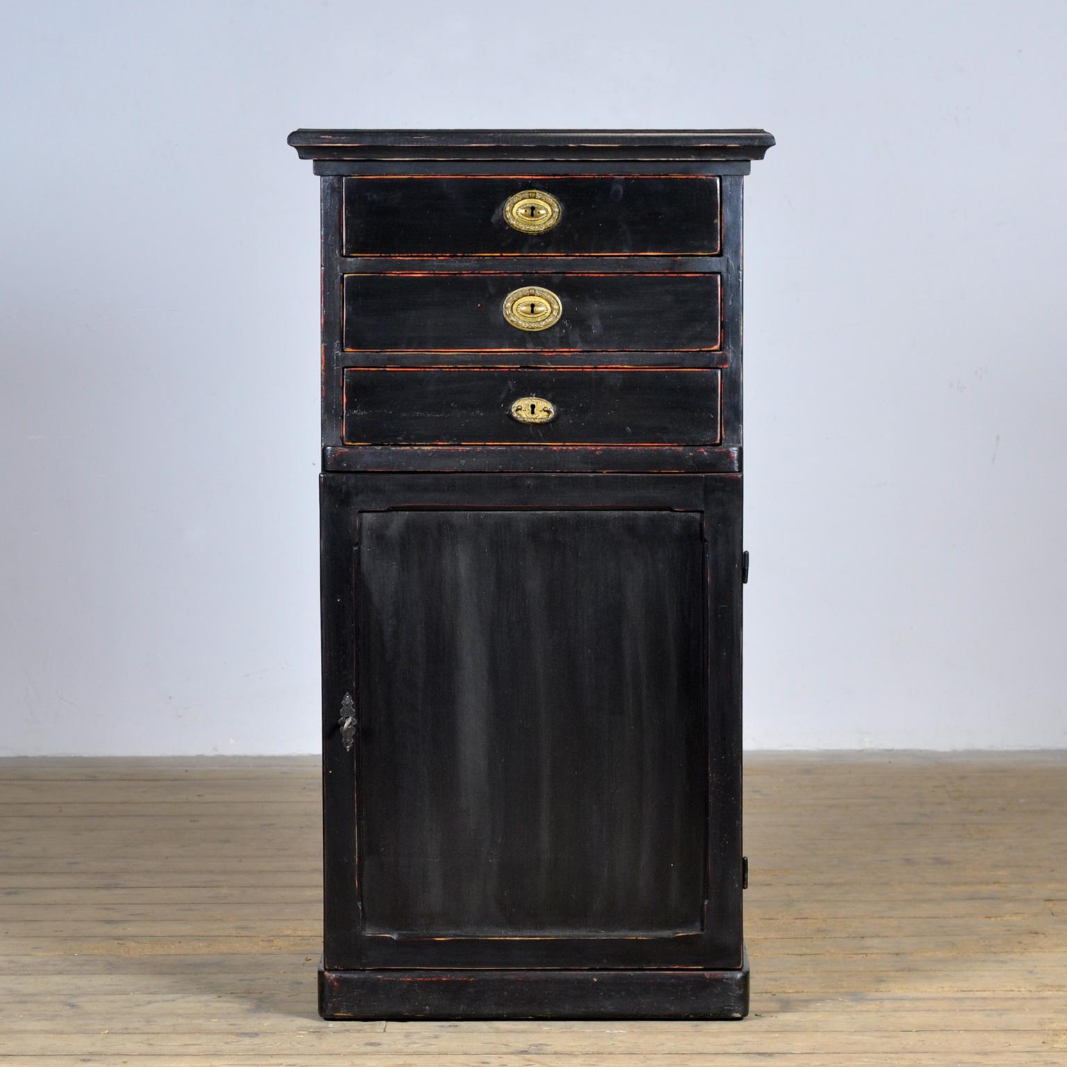 Mobile in legno di pino con i suoi accessori originali. Il mobile è stato realizzato negli anni '30 in Ungheria/Austria. In alto 3 cassetti e in basso, dietro l'anta, 2 ripiani. Un mobile pratico con tanto spazio per riporre gli oggetti. Nel corso