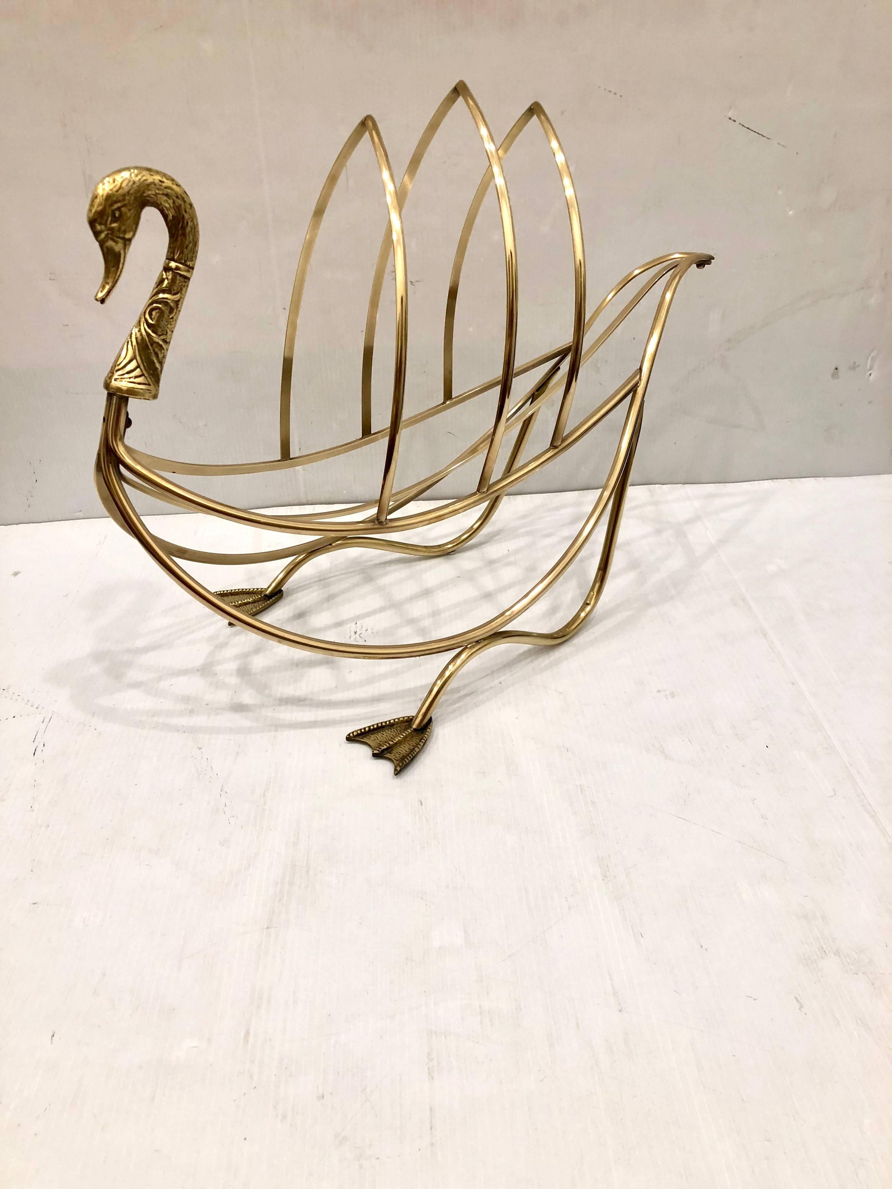A magazine or newspaper rack in solid polished brass swan with webbed feet and detailed brass neck and head. Made in Italy. In the manner of Parisian decorating firm Jansen.