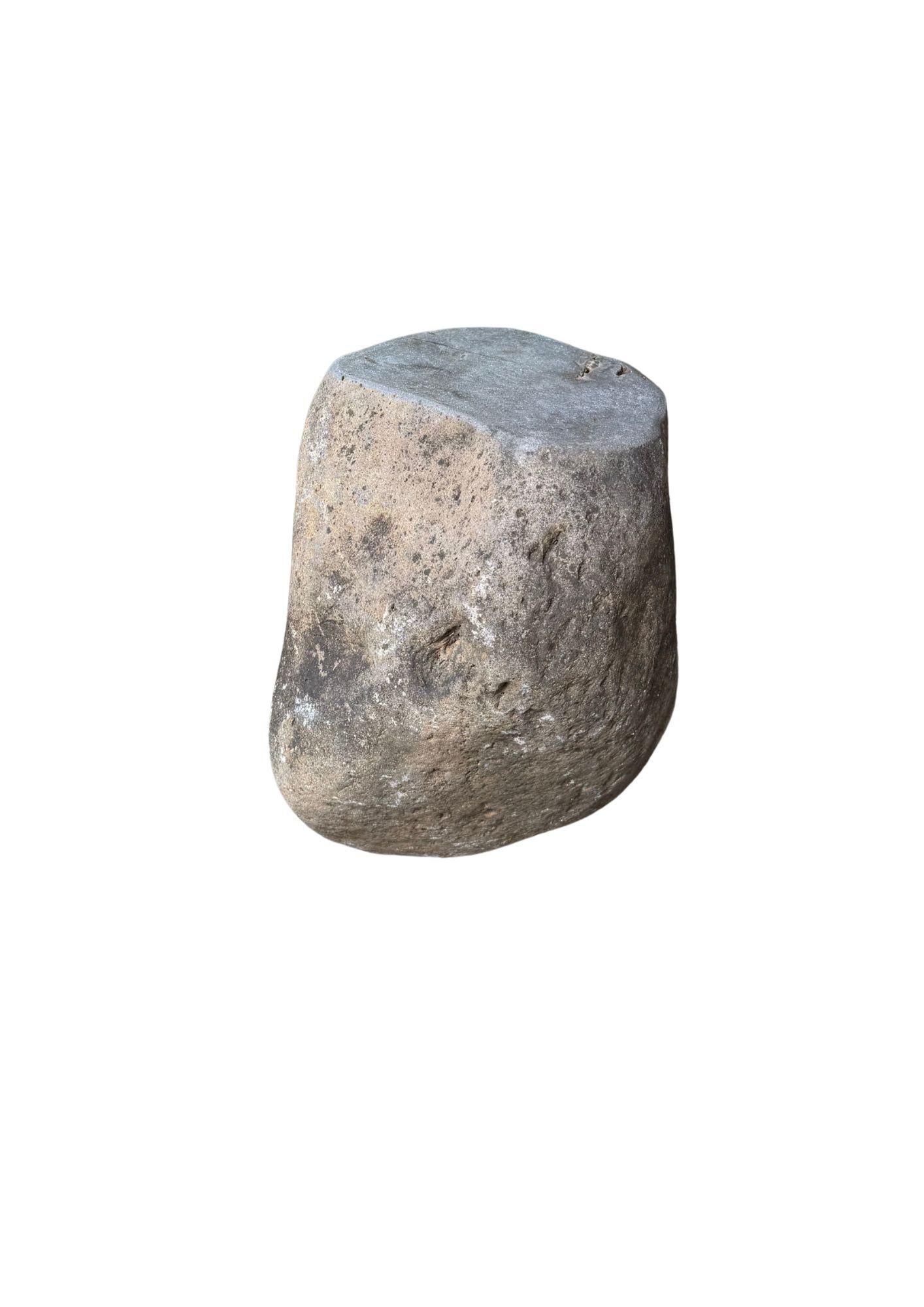 Dieser unglaublich schwere Beistelltisch aus massivem Stein, der aus einem Flussbett in Ostjava stammt, ist ein raffinierter Ausdruck der stillen Kraft und Schönheit der Natur. Aus einem einzigen, ungebrochenen Stück Flussgestein geschnitzt, ist