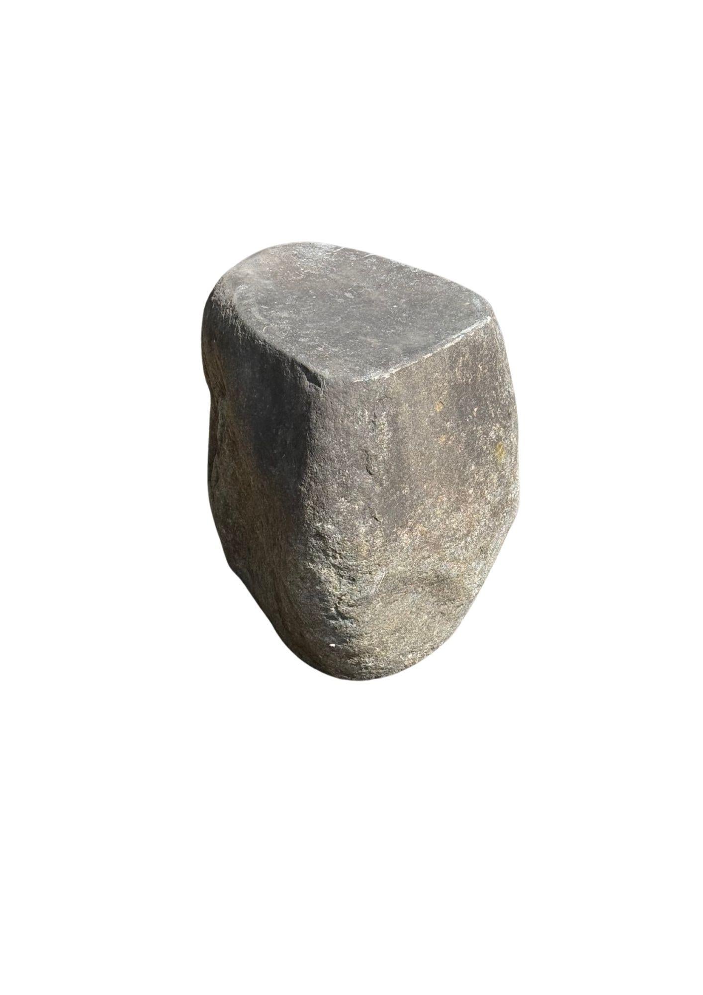 Dieser unglaublich schwere Beistelltisch aus massivem Stein, der aus einem Flussbett in Ostjava stammt, ist ein raffinierter Ausdruck der stillen Kraft und Schönheit der Natur. Aus einem einzigen, ungebrochenen Stück Flussgestein geschnitzt, ist