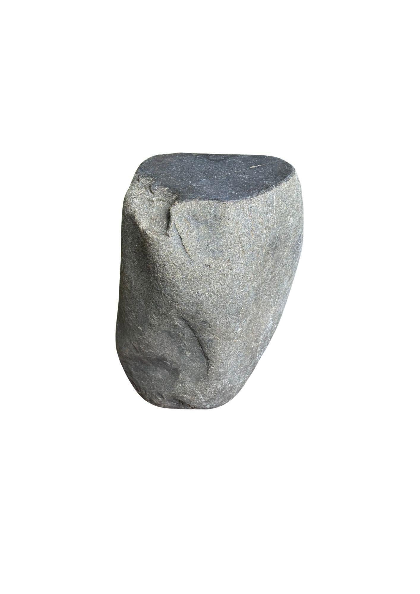 Dieser unglaublich schwere Beistelltisch aus massivem Stein, der aus einem Flussbett in Ostjava stammt, ist ein raffinierter Ausdruck der stillen Kraft und Schönheit der Natur. Aus einem einzigen, ungebrochenen Stück Flussgestein geschnitzt, ist