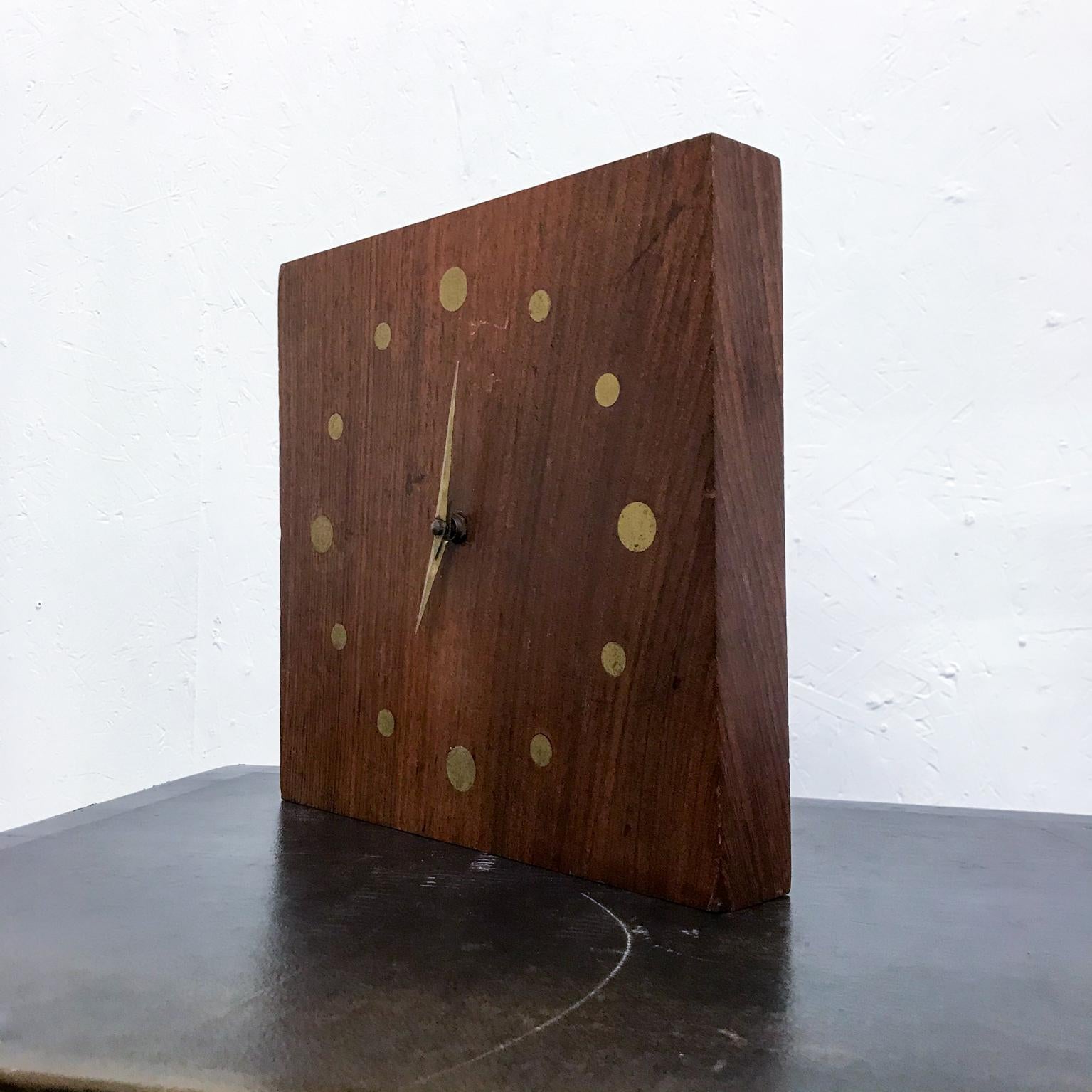 We are pleased to offer for your consideration, a Mid-Century Modern wall clock. Constructed with a solid rosewood block of wood with brass-bronze inserts. Original vintage unrestored patina. 

Battery movement on the back. Woodblock has a hole on