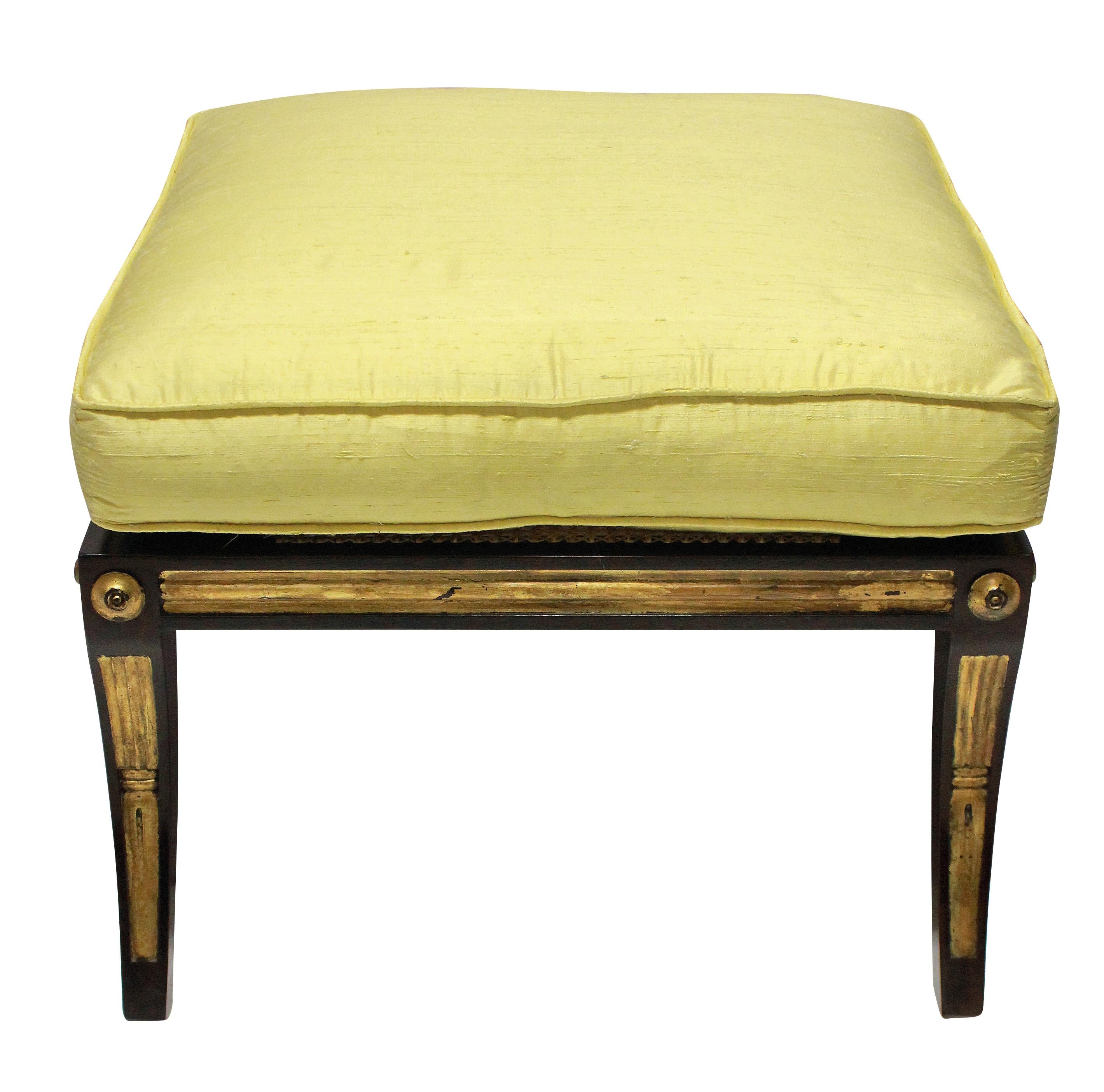 An English Regency style stool, in solid rosewood, with parcel-gilt detail and cane seat. The newly upholstered cushion in pale yellow silk.