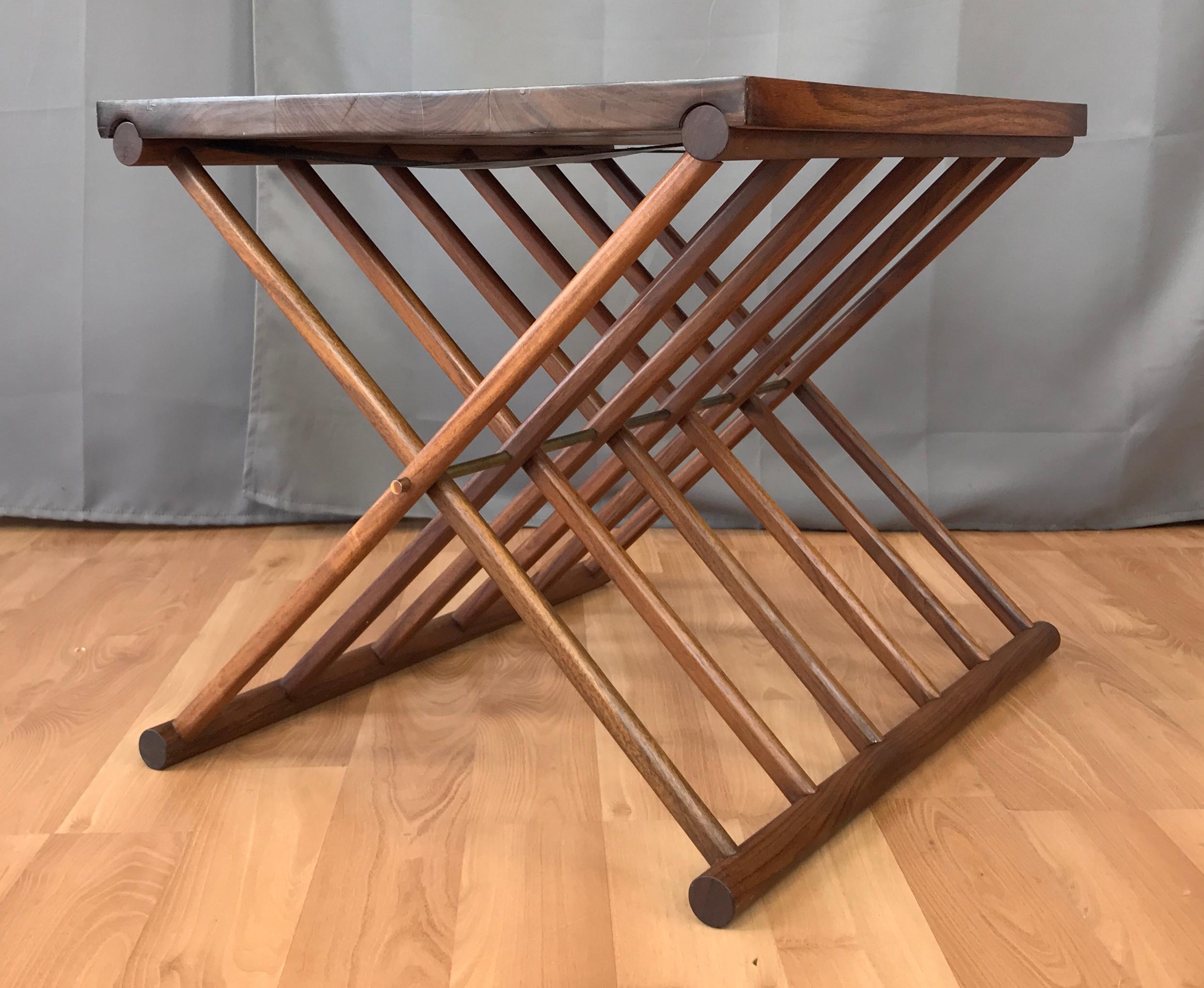 A very handsomely crafted, uncommon Danish modern rosewood occasional or side table with folding Campaign style X-base and removable top. 

Base features a solid rosewood dowel construction that pivots on a patinated solid brass rod. Exceptionally