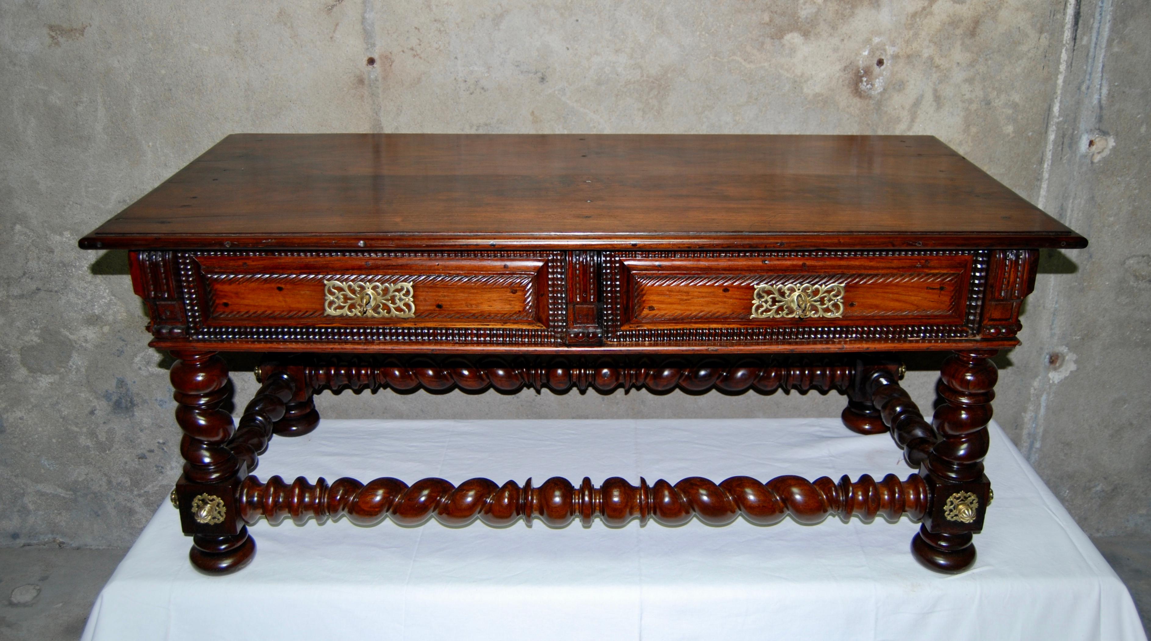 This remarkable table is made of solid rosewood, turned and richly carved.
Decorated with gilded bronze openwork at the feet and around the locks.
The 4 legs are connected by turned wood stretchers.
It has two drawers opening on one side, with