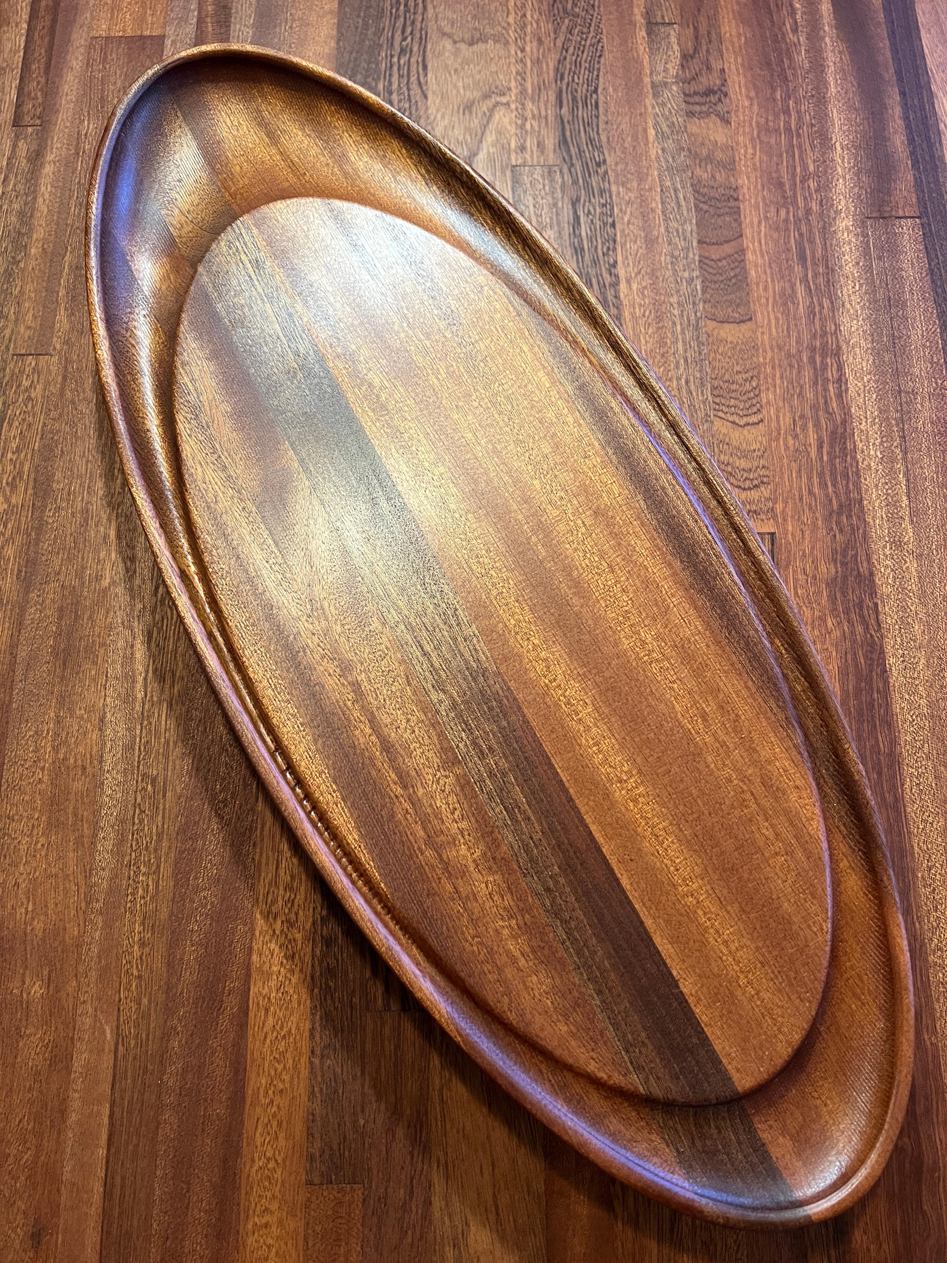 Carved Solid Sapele Oval butcher block with extended oval drip edge in stock For Sale