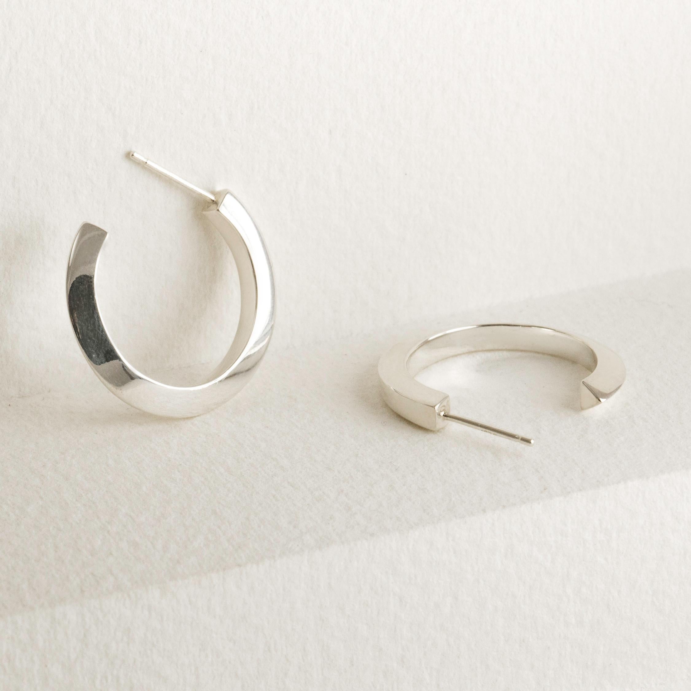 The Medium Flow Hoop earrings begins as a square and smoothly transforms into a triangle. These earrings are a versatile and elegant statement, a timeless reimagining of a classic.  Crafted in solid 14k gold, the The Medium Flow Hoop is designed to