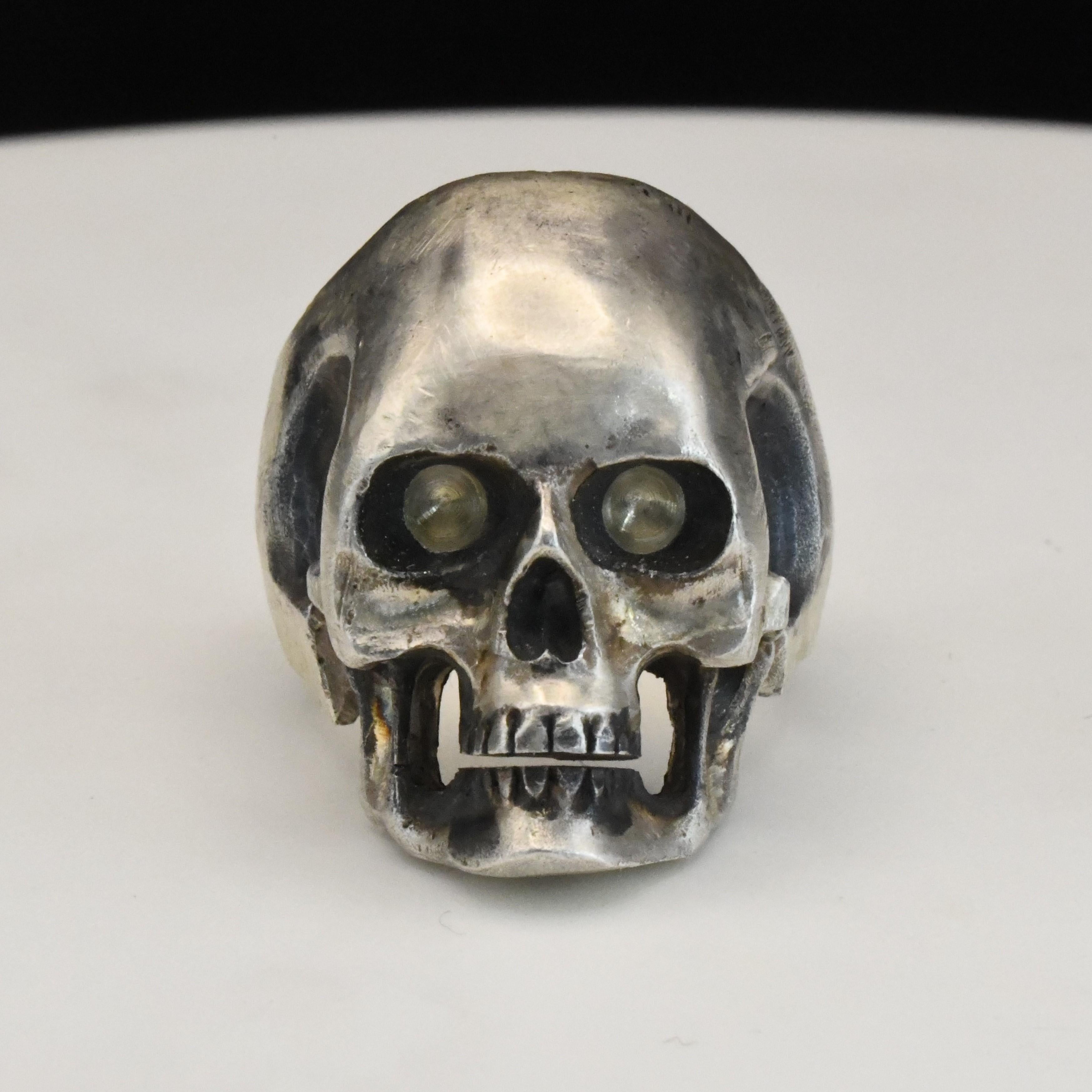 Anello teschio in argento massiccio fatto a mano

Le grandi dimensioni conferiscono una presenza dominante.

Rifinito intenzionalmente in modo grezzo che si adatta perfettamente al design.

Realizzato interamente in argento 925 con effetti di