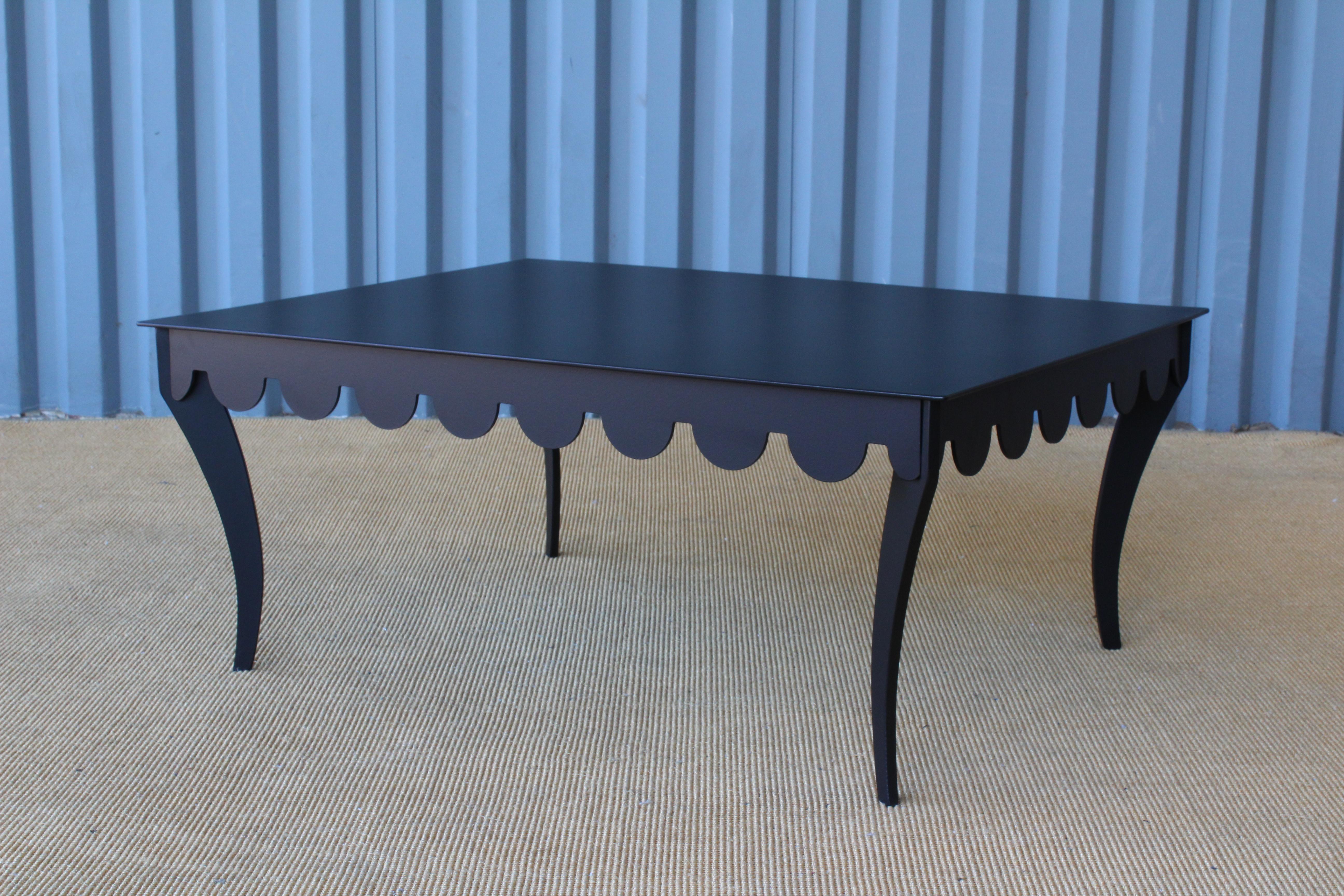 Solid steel indoor or outdoor coffee table. Recently powder coated in black. Features a scalloped cut detailed edge and Klismos style legs. Unknown make, unknown year. Possibly a one of a kind table.