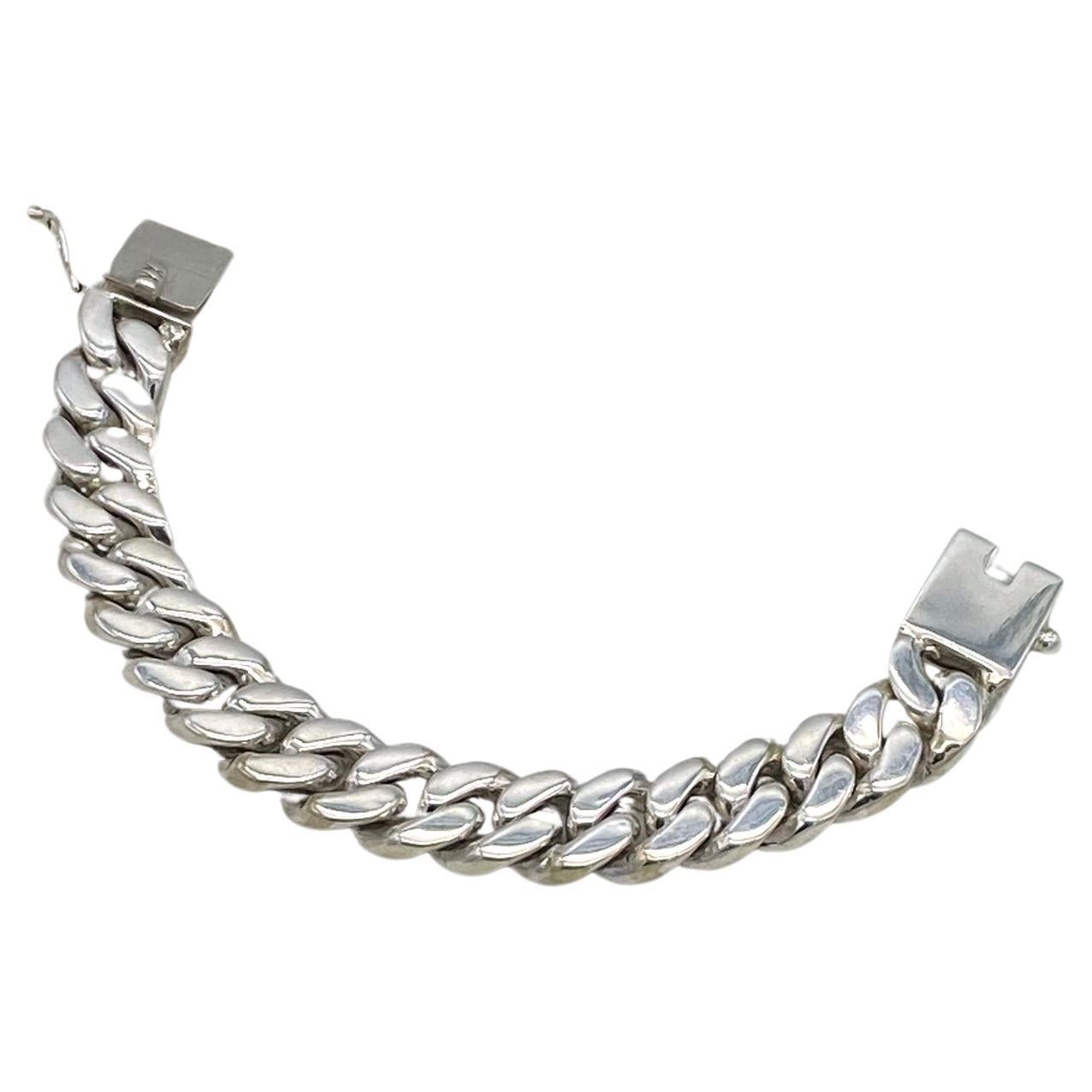 This is a solid sterling silver cuban link bracelet. It is over 111 grams with a polished sterling finish,
a square box clasp and an extra side security clasp. This cuban link bracelet was crafted by a Thai silver-smith. Perfect for men too!

Our